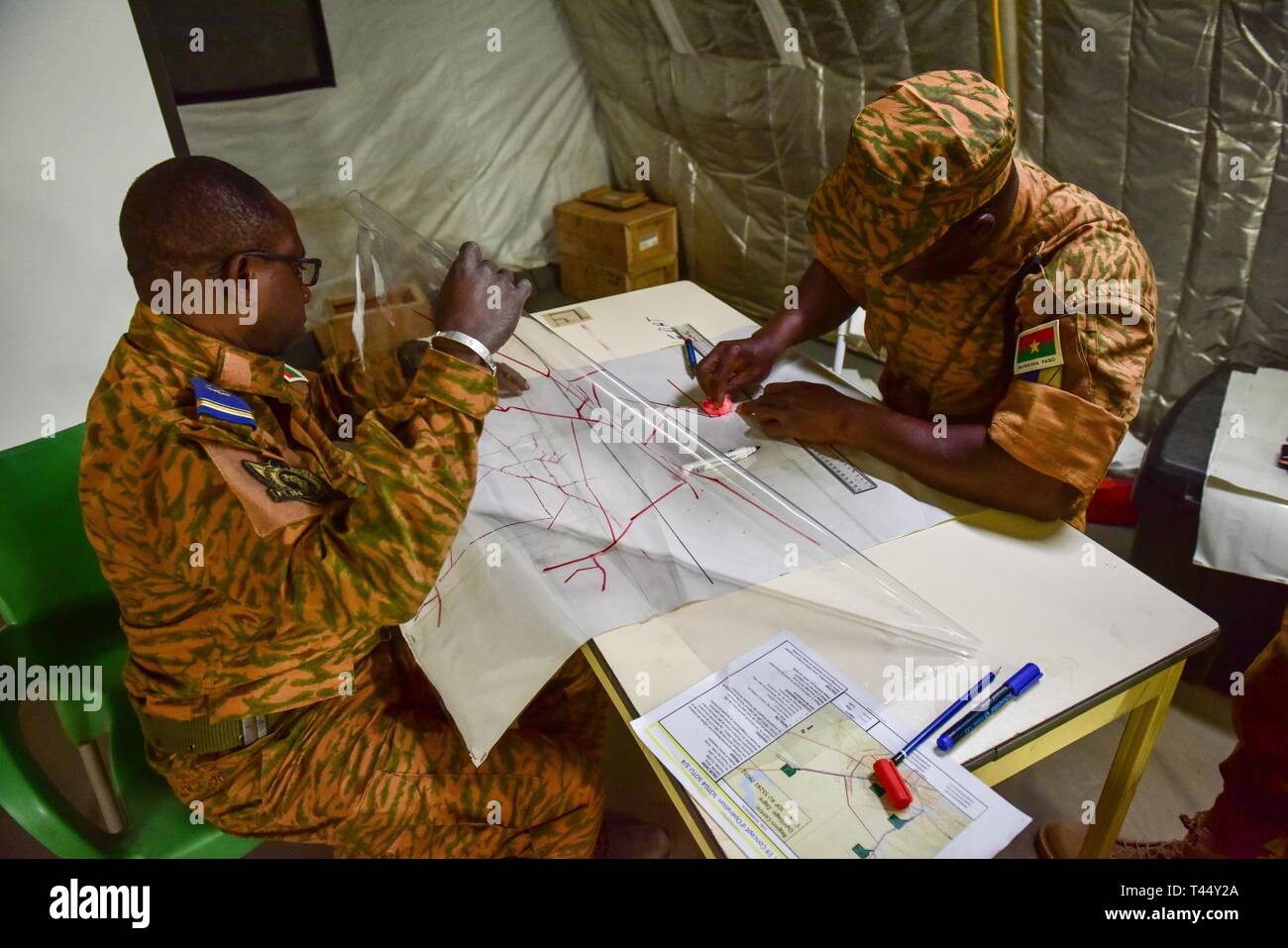 Burkina Faso Army leadership staying at base camp Loumbila conduct operations planning on Feb. 24, 2019 during exercise Flintlock 19. This team of Burkina Faso military leaders are in charge of providing command and control for all multinational western partners in Loumbila during the exercise's scenerio days. The Flintlock series of exercises provide military training opportunities that help foster relationships of peace, security, and cooperation. Stock Photo