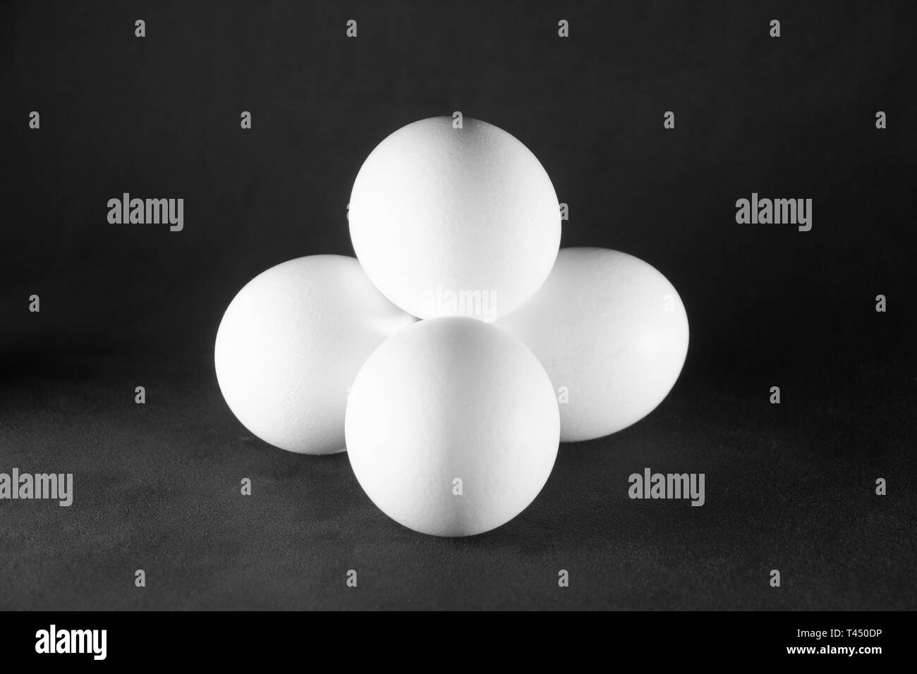 White chicken eggs on black background Stock Photo - Alamy