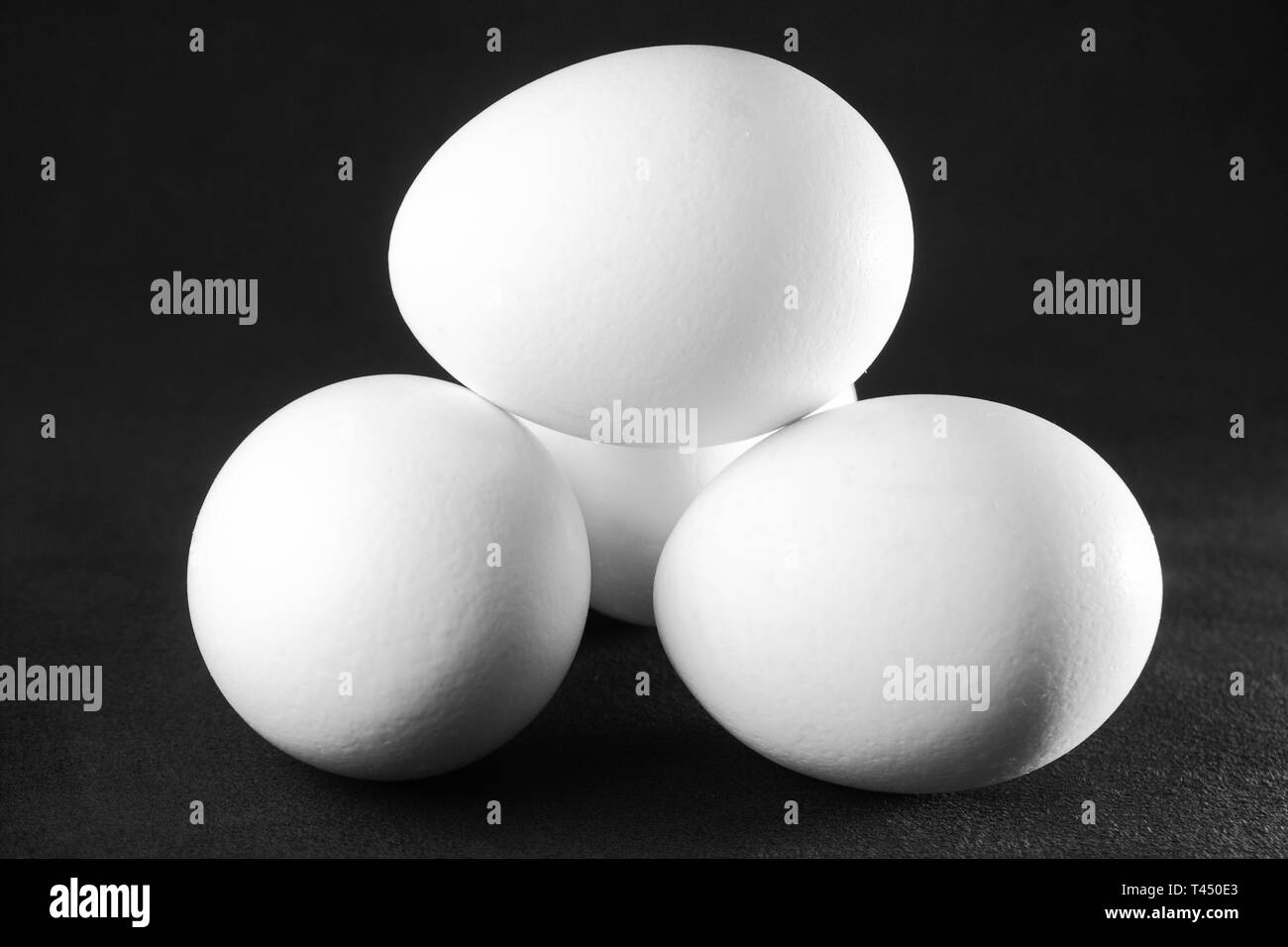 White chicken eggson black background Stock Photo - Alamy