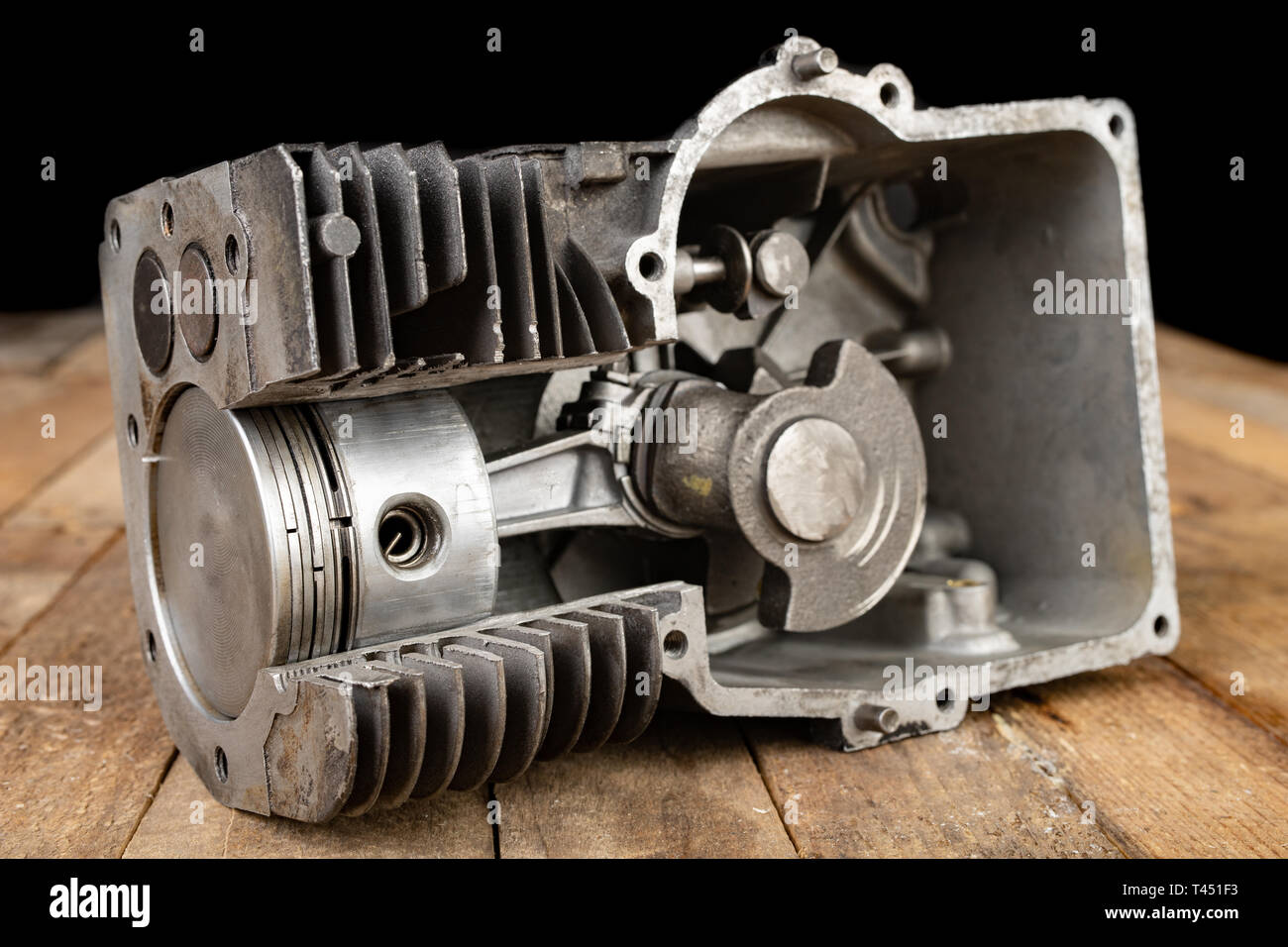 A four-stroke gasoline engine in section. The interior of a single-cylinder internal combustion engine. Dark background. Stock Photo