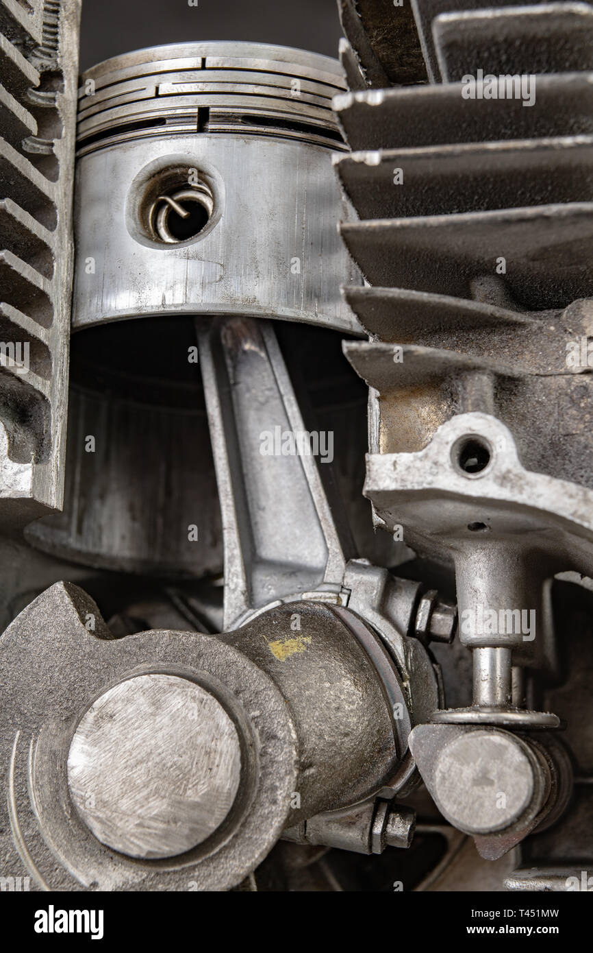 A four-stroke gasoline engine in section. The interior of a single-cylinder internal combustion engine. Dark background. Stock Photo