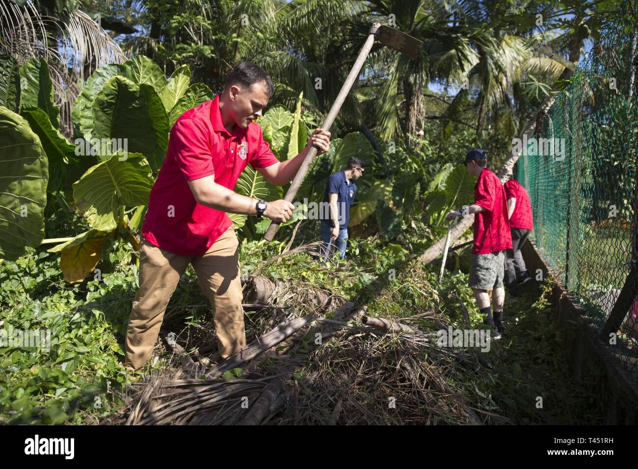 Cpl. John Robinson, a radio operator with Alpha Company, Battalion Landing Team, 1st Battalion, 4th Marines, the “China Marines,” clears vegetation from a fence at the Sabah Cheshire Home and Services during a community relations event in Sabah, Malaysia, Feb. 26, 2019. During the visit, the Marines and Sailors helped clean and renovate the facility by painting, clearing overgrown vegetation, and organizing storage space. Robinson, a native of Lafayette, Louisiana, graduated from Comeaux High School in May 2013 before enlisting in August 2016. Alpha Company Marines are the small boat raid spec Stock Photo