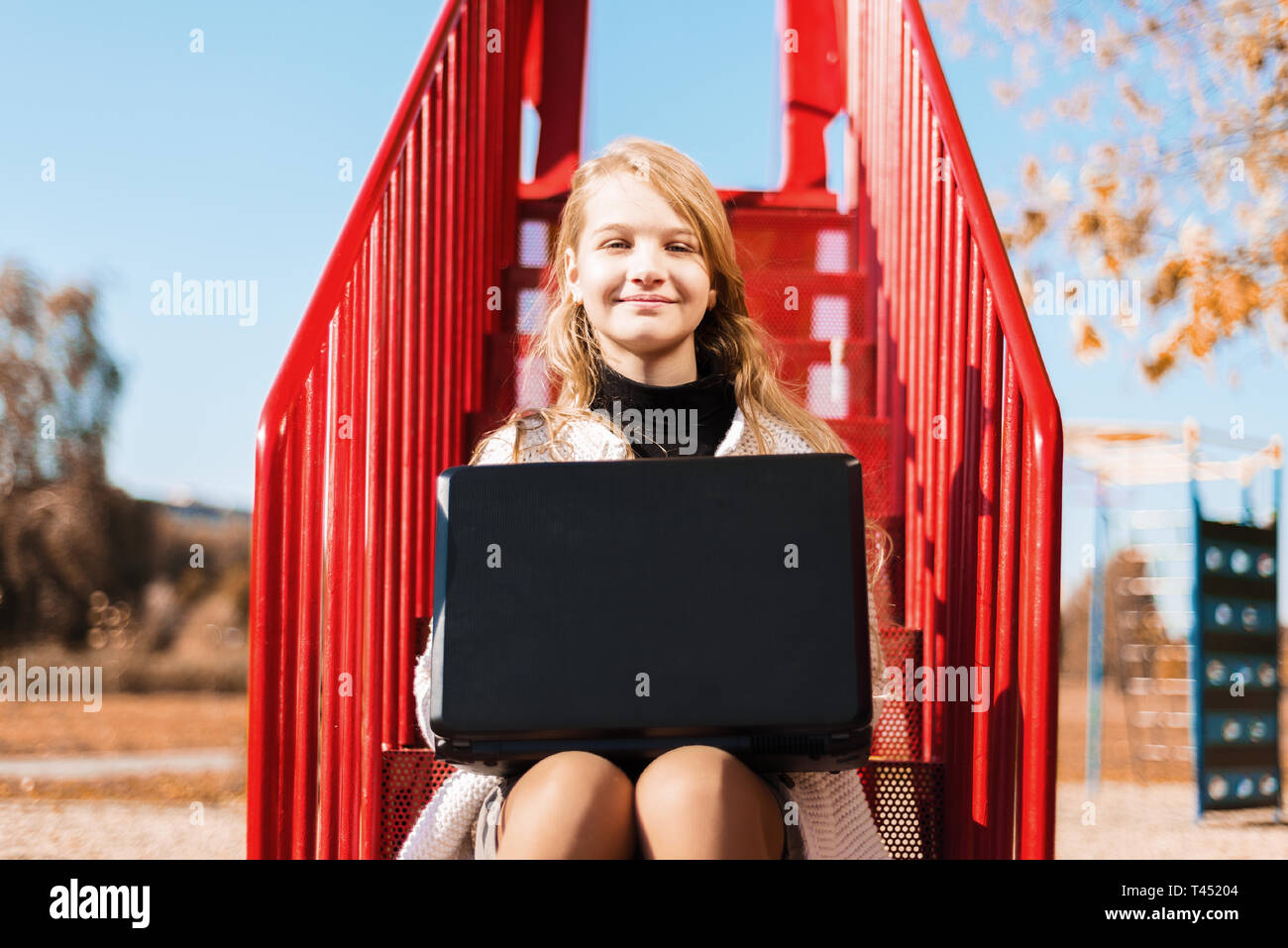 Schoolgirl student smiles. young girl sitting on the red stairs and ...