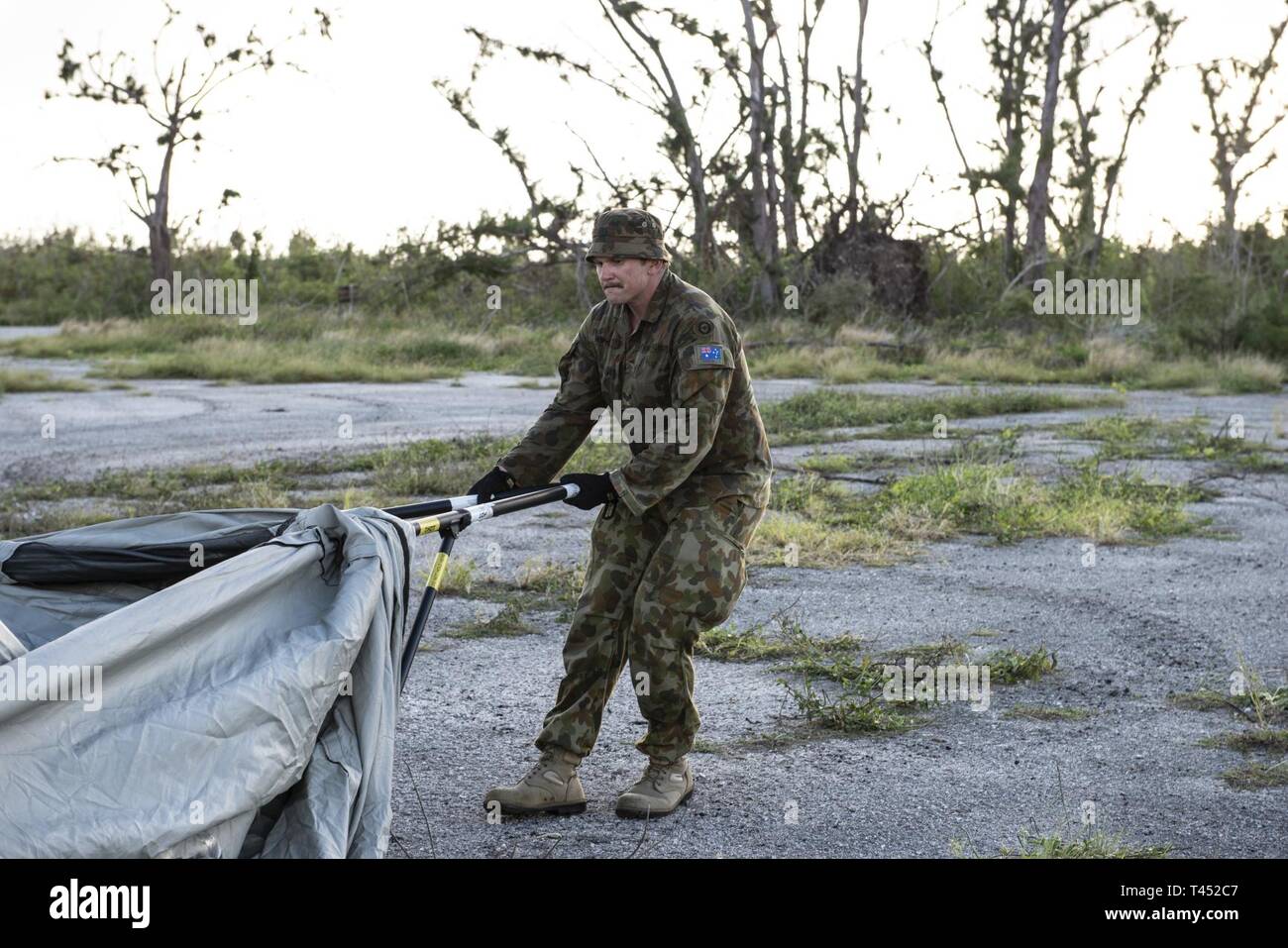 A Royal Australian Air Force member prepares to build tents during exercise Cope North 19 in Tinian, U.S. Commonwealth of the Northern Marianas Islands Feb 26, 2019. Cope North is an annual multilateral U.S. Pacific Air Forces-sponsored field training exercise focused on combat air forces large-force employment and mobility air forces humanitarian assistance and disaster relief training to enhance interoperability among U.S., Australian and Japanese forces. Stock Photo