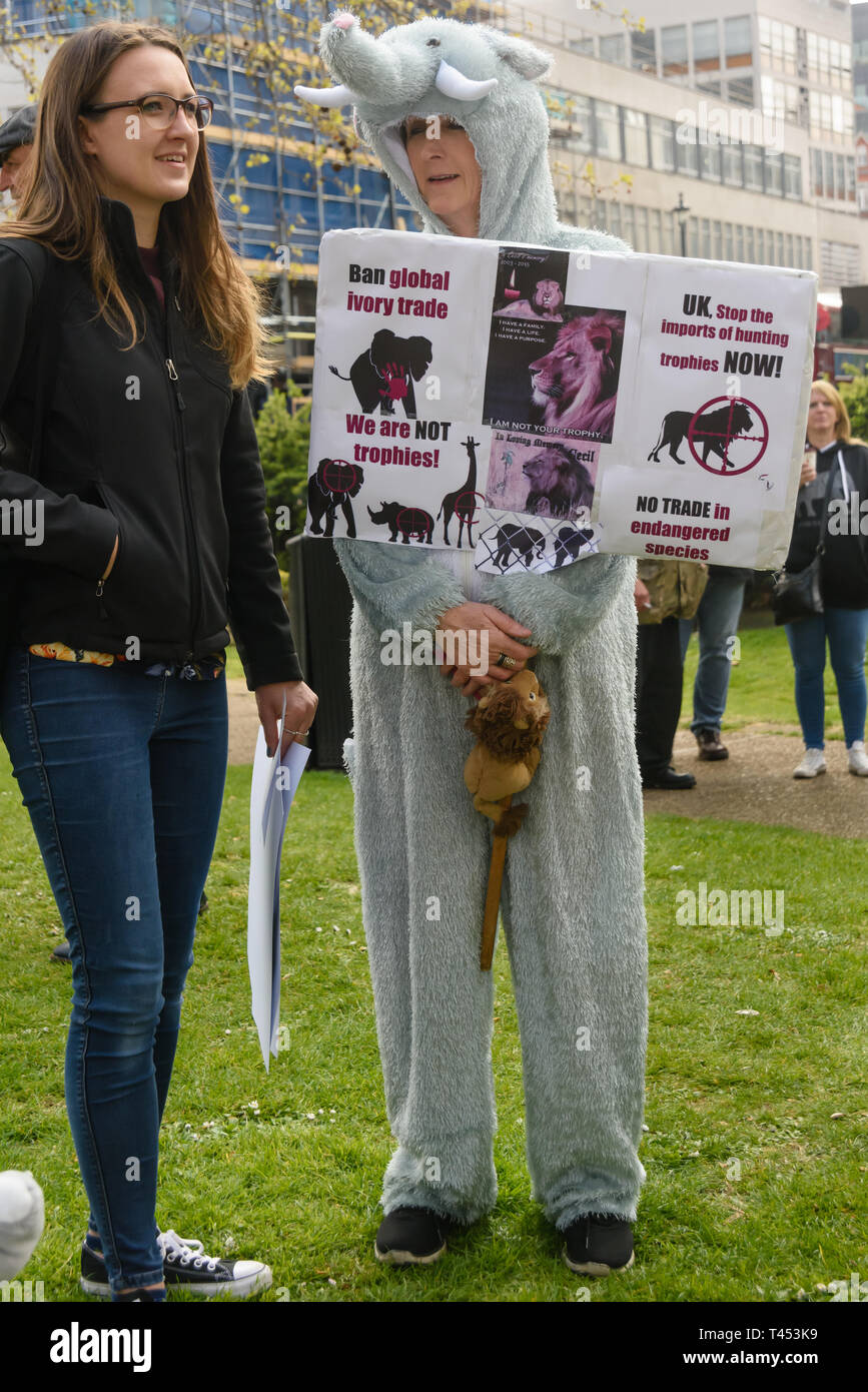 London, UK. 13th April 2014. People, some wearing animal costumes, meet in Cavendish Square to march through London  to a rally opposite Downing St as a part of the 2019 Global March for Elephants and Rhinos. They called on the UK government to impose a ban on the import of hunting trophies of endangered species to the UK, and supported an increase in the protection under CITES for elephants and opposed attempts to downgrade protection of endangered species or reopen trade in ivory and other body parts. Peter Marshall/Alamy Live News Stock Photo