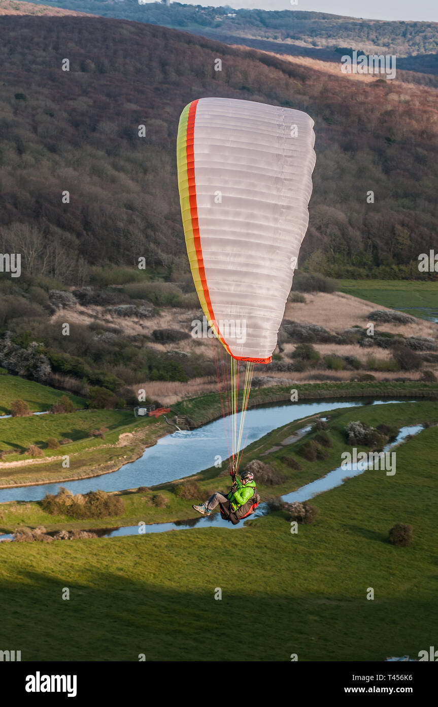 Seaford, East Sussex, UK. 13th Apr 2019. Colder wind from the East brings paraglider pilots to High & Over in the beautiful South Downs overlooking the Cuckmere River. Stock Photo