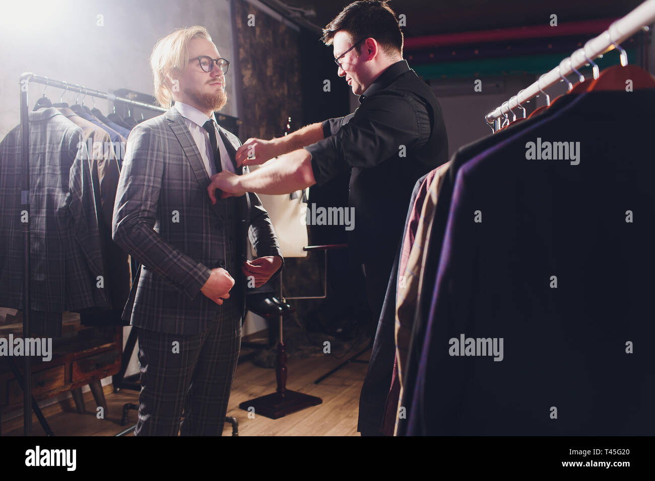 Mature professional Tailor taking measurements for sewing suit at ...