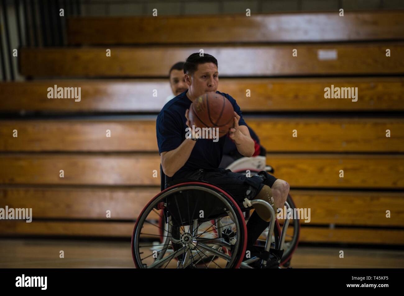 Staff Sgt. Jason Pacheco moves the ball down court during a 2019 Marine Corps Trials wheelchair basketball practice session at Marine Corps Base Camp Pendleton, California, March 1. The Marine Corps Trials promotes recovery and rehabilitation through adaptive sports participation and develops camaraderie among recovering service members and veterans. Additionally, the competition is an opportunity for participants to demonstrate physical and mental achievements and serves as the primary venue to select Marine Corps participants for the DoD Warrior Games. Stock Photo