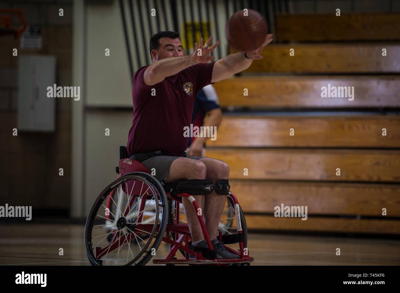 A U.S. Marine Corps athlete passes the ball during a 2019 Marine Corps Trials wheelchair basketball practice session at Marine Corps Base Camp Pendleton, California, March 1. The Marine Corps Trials promotes recovery and rehabilitation through adaptive sports participation and develops camaraderie among recovering service members and veterans. Additionally, the competition is an opportunity for participants to demonstrate physical and mental achievements and serves as the primary venue to select Marine Corps participants for the DoD Warrior Games. Stock Photo