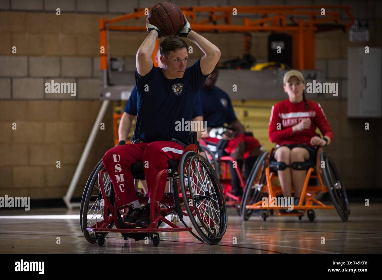 A U.S. Marine Corps athlete prepares to pass during a 2019 Marine Corps Trials wheelchair basketball practice session at Marine Corps Base Camp Pendleton, California, March 1. The Marine Corps Trials promotes recovery and rehabilitation through adaptive sports participation and develops camaraderie among recovering service members and veterans. Additionally, the competition is an opportunity for participants to demonstrate physical and mental achievements and serves as the primary venue to select Marine Corps participants for the DoD Warrior Games. Stock Photo