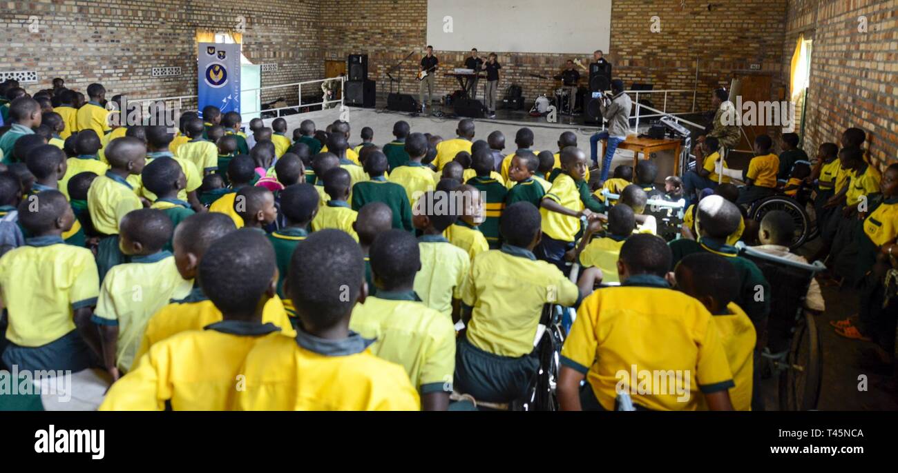 Students of the Home de la vierge des Pauvres Gatagara/Nyanza listen to music played by the U.S. Air Forces in Europe Band Touch N' Go in the Nyanza District, Rwanda, March 5, 2019. The USAFE Band played for HVP Nyanza as part of an outreach event. The band uses these events to further increase cultural ties and enhance the people-to-people relationship between the United States and its partners such as Rwanda. Stock Photo