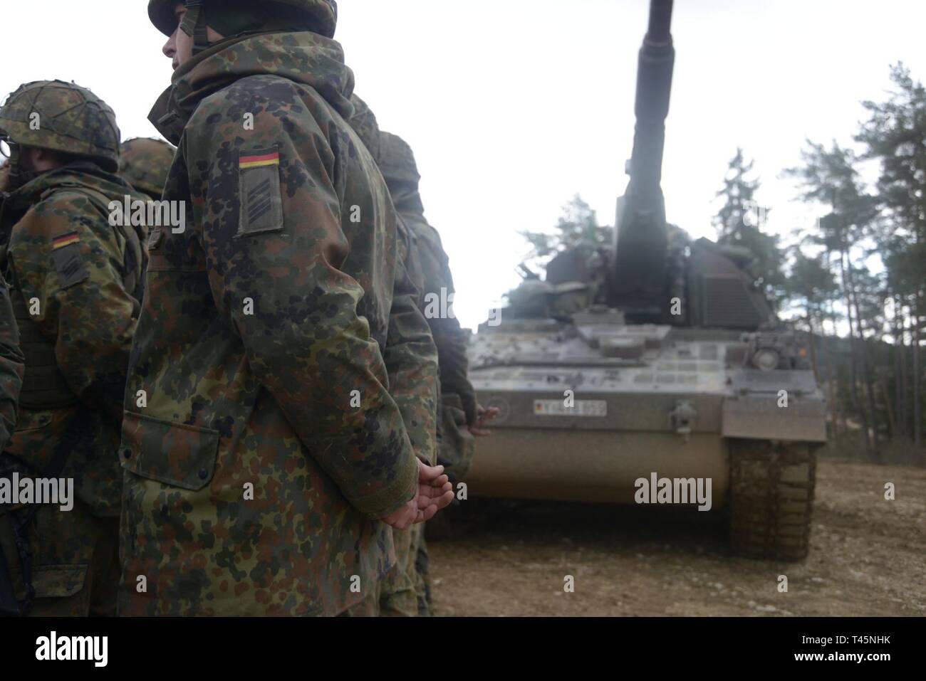 German soldiers, assigned to 131st Field Artillery Battalion, stand in formation for an after action review during exercise Dynamic Front 19 at the 7th Army Training Command's Grafenwoehr Training Area, Germany, March 5, 2019. Exercise Dynamic Front 19 includes approximately 3,200 service members from 27 nations who are observing or participating from Grafenwoehr Training Area, Germany; Riga, Latvia; and Torun, Poland; during March 2-9, 2019. Dynamic Front is an annual U.S. Army Europe exercise focused on the readiness and interoperability of U.S. Army, joint service, and allied and partner na Stock Photo