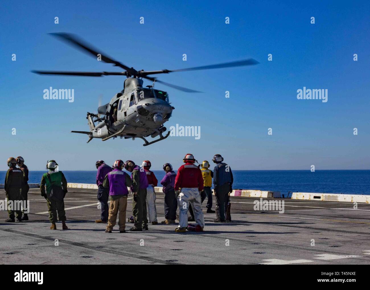 MEDITERRANEAN SEA (Mar. 5, 2019) A UH-1Y Huey helicopter assigned to the “Black Knights” of Marine Medium Tiltrotor Squadron (VMM) 264 (Reinforced) lands on the flight deck of the San Antonio-class amphibious transport dock ship USS Arlington (LPD 24), Mar. 5, 2019. Arlington is on a scheduled deployment as part of the Kearsarge Amphibious Ready Group in support of maritime security operations, crisis response and theater security cooperation, while also providing a forward naval presence. Stock Photo