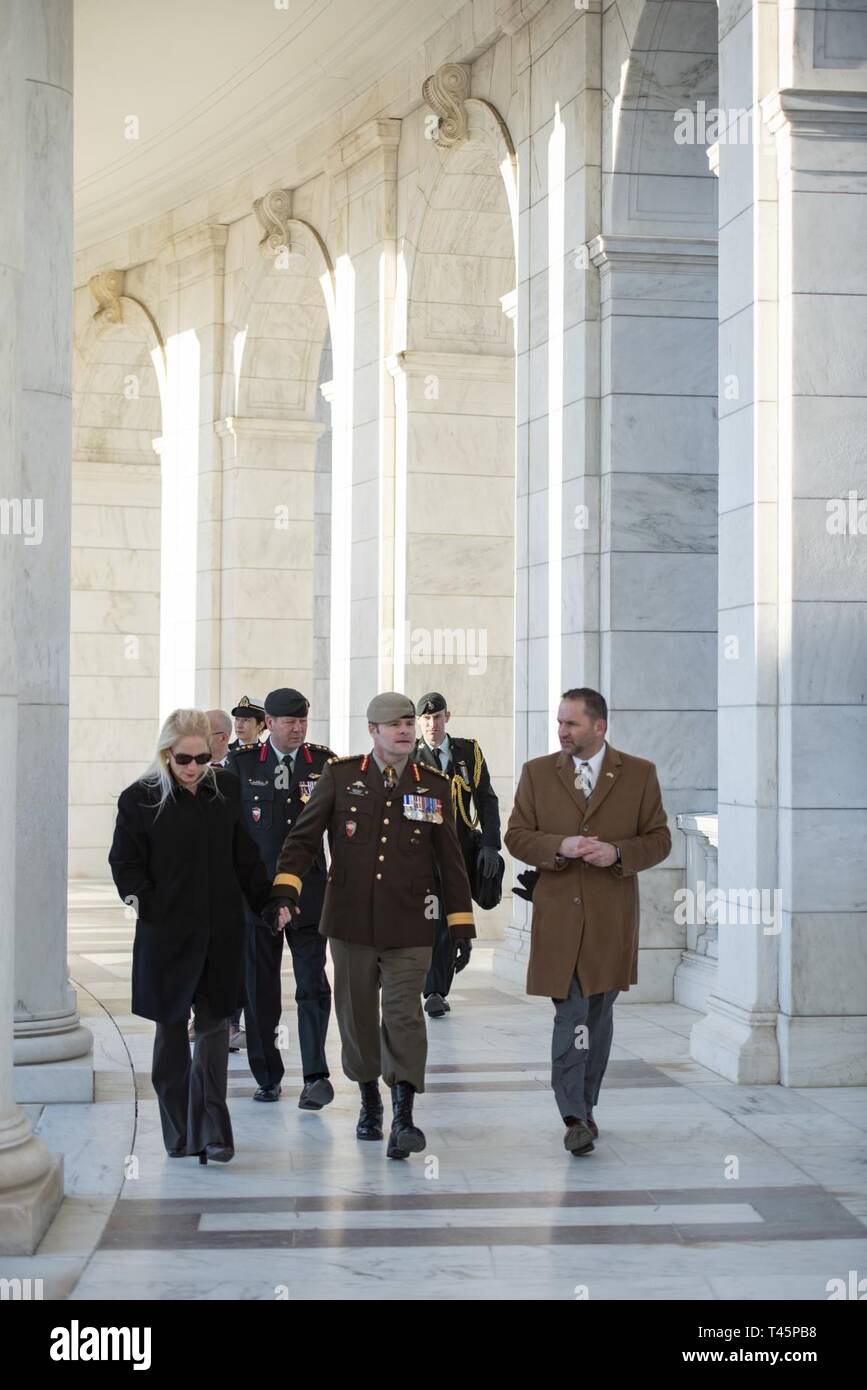 Lt. Gen. M.N. (Mike) Rouleau (center), commander, Canadian Joint Operations Command;  his partner, Andrea Themely (left); and Michael Migliara (right), director of operations, Arlington National Cemetery; walk through the Memorial Amphitheater at Arlington National Cemetery, Arlington, Virginia, March 6, 2019. Rouleau participated in an Armed Forces Full Honors Wreath-Laying Ceremony at the Tomb of the Unknown Soldier and toured the Memorial Amphitheater Display Room as part of his visit. Stock Photo