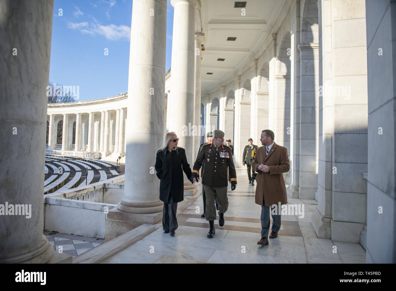 Lt. Gen. M.N. (Mike) Rouleau (center), commander, Canadian Joint Operations Command;  his partner, Andrea Themely (left); and Michael Migliara (right), director of operations, Arlington National Cemetery; walk through the Memorial Amphitheater at Arlington National Cemetery, Arlington, Virginia, March 6, 2019. Rouleau participated in an Armed Forces Full Honors Wreath-Laying Ceremony at the Tomb of the Unknown Soldier and toured the Memorial Amphitheater Display Room as part of his visit. Stock Photo