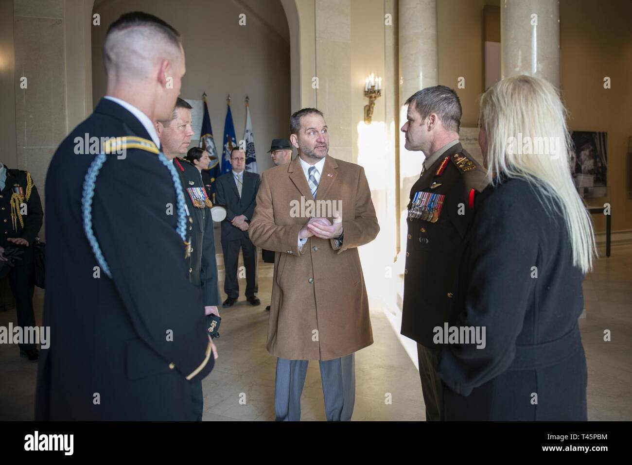 (From left) U.S. Army Capt. Victor Farrar, commander of the guard, U.S. Infantry Regiment (The Old Guard); Col. Alan Mulawyshyn, Canadian Armed Forces; Michael Migliara, director of operations, Arlington National Cemetery; Lt. Gen. M.N. (Mike) Rouleau, commander, Canadian Joint Operations Command; and his partner, Andrea Themely; speak in the Memorial Amphitheater Display Room at Arlington National Cemetery, Arlington, Virginia, March 6, 2019. While at ANC, Rouleau participated in a Public Wreath-Laying Ceremony at the Tomb of the Unknown Soldier and toured the Memorial Amphitheater Display Ro Stock Photo