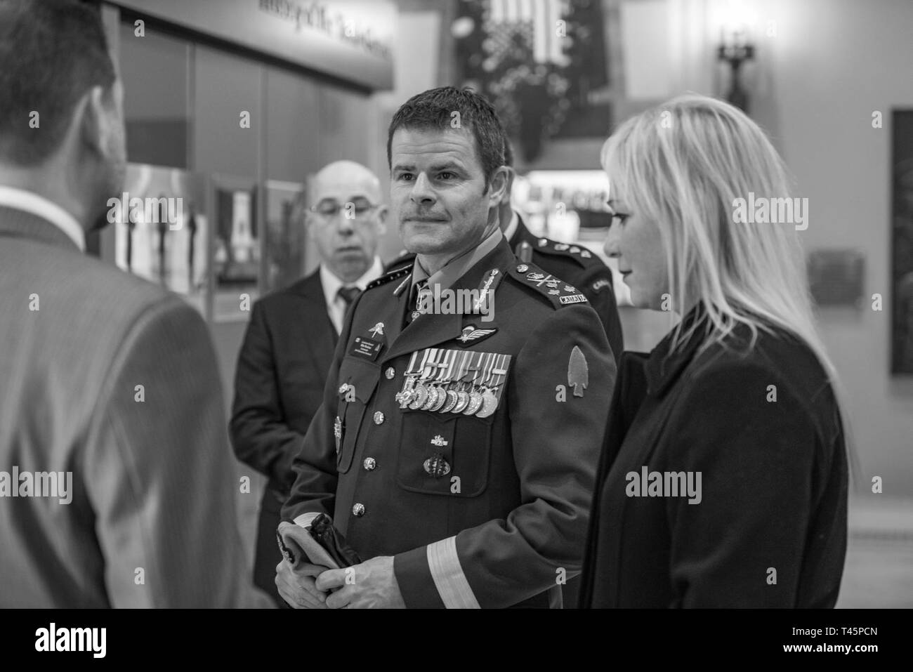 Michael Migliara (left), director of operations, Arlington National Cemetery; speaks with Lt. Gen. M.N. (Mike) Rouleau (center), commander, Canadian Joint Operations Command; and his partner, Andrea Themely (right); in the Memorial Amphitheater Display Room at Arlington National Cemetery, Arlington, Virginia, March 6, 2019. While at the cemetery, Rouleau participated in a Public Wreath-Laying Ceremony at the Tomb of the Unknown Soldier and observed the Changing of the Guard. Stock Photo