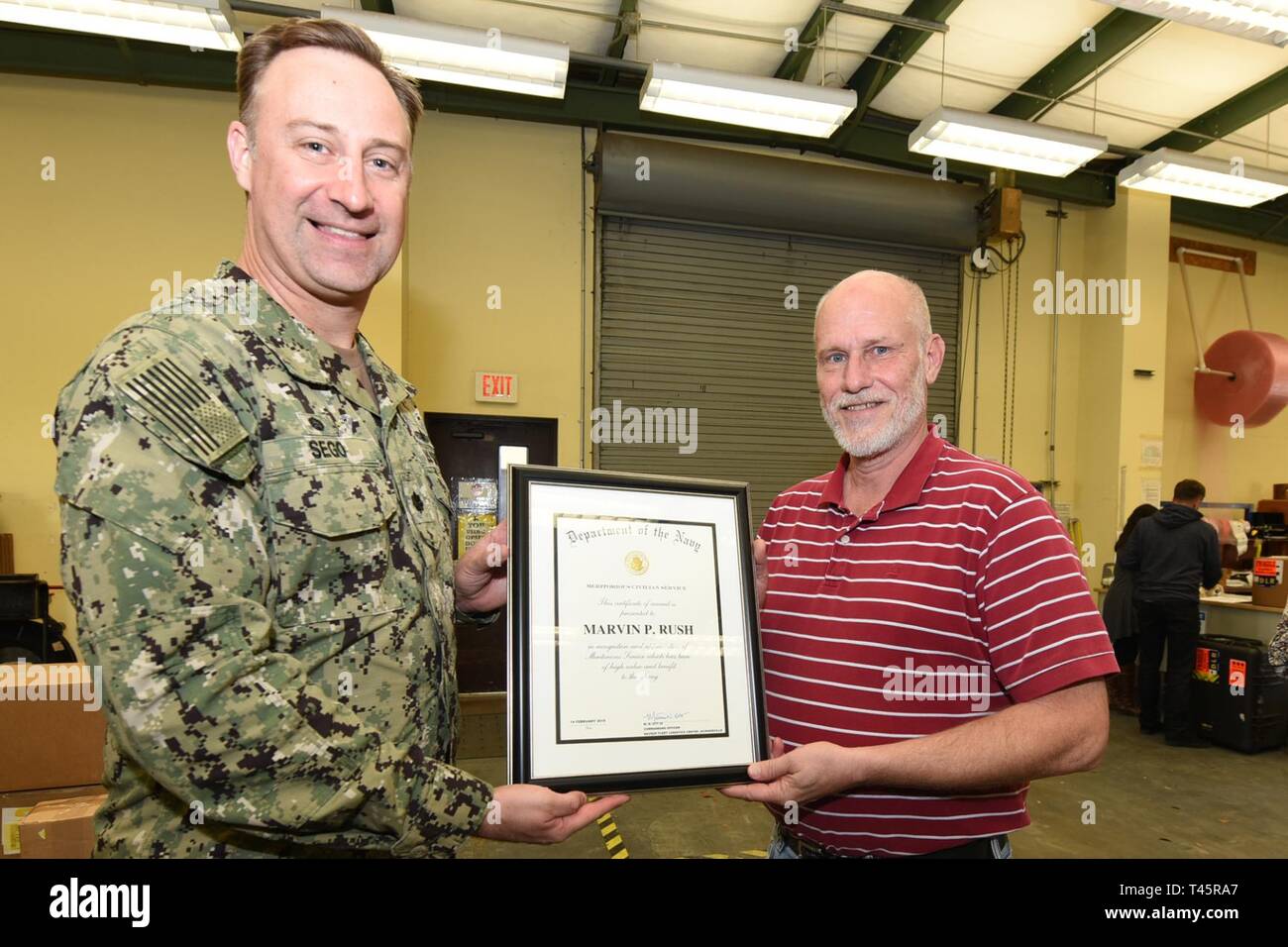 Panama City, FL -- (Mar. 7, 2019) Mr. Marty Walsh, site director for Naval Supply Command, Fleet Logistics Center- Panama City is presented the Navy Meritorious Civilian Service Award by Naval Support Activity Panama City commanding officer Cmdr. Jay Sego on behalf of the Fleet Logistics Center Jacksonville.  Mr. Walsh was cited for his outstanding meritorious service and superior performance of his duties while supporting the NSA Panama City Emergency Operations Center during Hurricane Michael recovery efforts.  His team quickly and effectively provided fuel, food, and water support to the ba Stock Photo