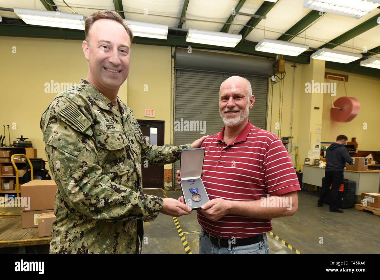 Panama City, FL -- (Mar. 7, 2019) Mr. Marty Walsh, site director for Naval Supply Command Fleet Logistics Center- Panama City is presented the Navy Meritorious Civilian Service Award by Naval Support Activity Panama City commanding officer Cmdr. Jay Sego on behalf of the Fleet Logistics Center Jacksonville.  Mr. Walsh was cited for his outstanding meritorious service and superior performance of his duties while supporting the NSA Panama City Emergency Operations Center during Hurricane Michael recovery efforts.  His team quickly and effectively provided fuel, food, and water support to the bas Stock Photo