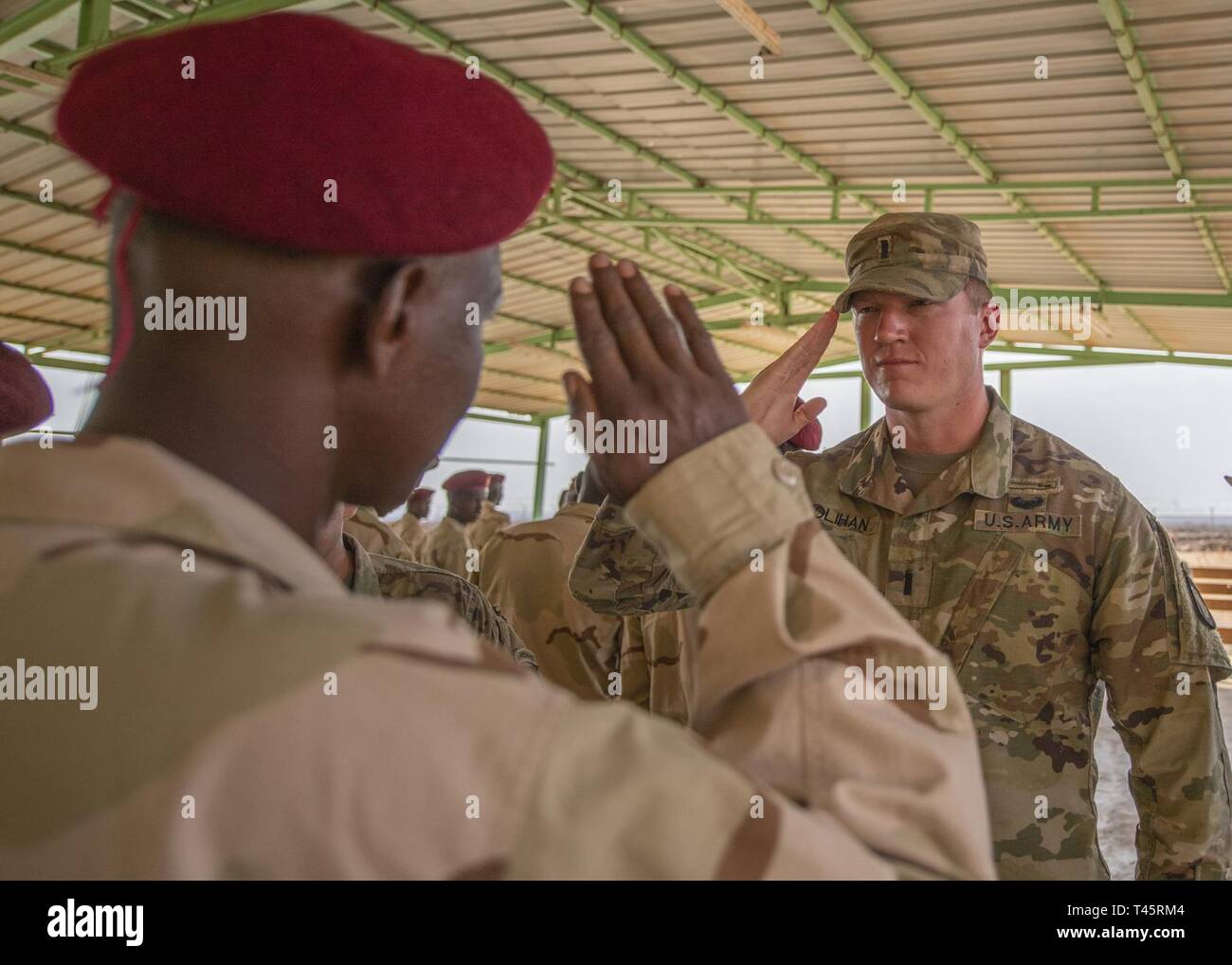 U.S. Army 1st Lt. Travis Holihan, the officer in charge of NCO training, Headquarters Company, 1-26 Infantry Battalion, 2nd Brigade Combat Team, 101st Airborne, assigned to Combined Joint Task Force-Horn of Africa, returns a salute during an NCO course graduation for the Rapid Intervention Battalion (RIB), a Djiboutian army elite military force, at a training location near Djibouti, March 7, 2019. U.S. Soldiers with Holihan’s unit taught the course to the RIB soldiers. Stock Photo