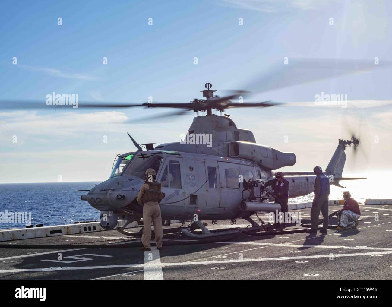 MEDITERRANEAN SEA (Mar. 8, 2019) Sailors refuel a UH-1Y Huey helicopter assigned to the “Black Knights” of Marine Medium Tiltrotor Squadron (VMM) 264 (Reinforced) on the flight deck of the San Antonio-class amphibious transport dock ship USS Arlington (LPD 24), Mar. 8, 2019. Arlington is on a scheduled deployment as part of the Kearsarge Amphibious Ready Group in support of maritime security operations, crisis response and theater security cooperation, while also providing a forward naval presence. Stock Photo