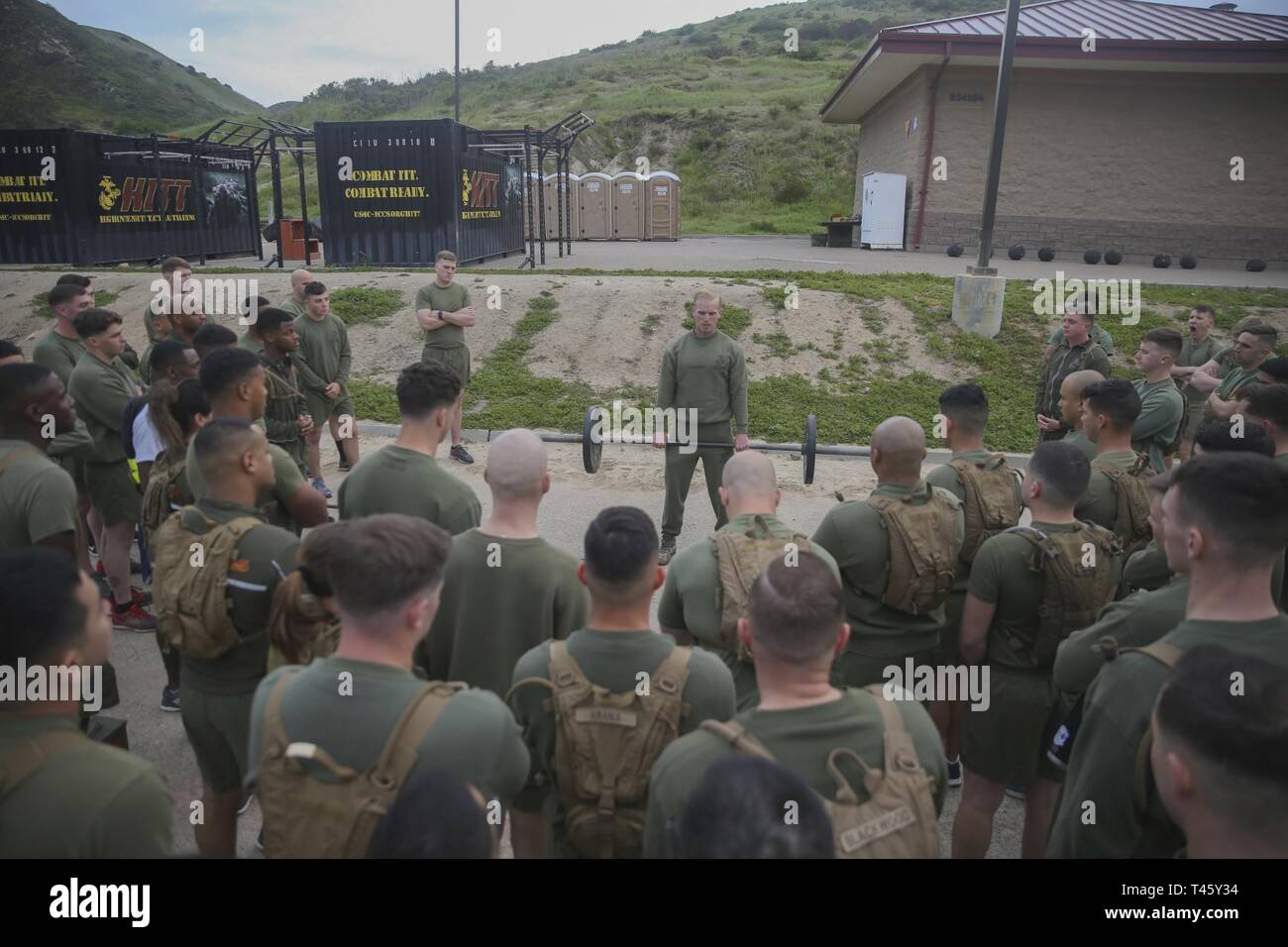 U.S. Marine Corps Sgt. Billy Manning, team leader, 1st Recon Force Company, demonstrates barbell thrusters as part of a physical fitness training session during Sergeants Course at the Staff Non-Commissioned Officer Academy, Marine Corps Base Camp Pendleton, California, March 11, 2019. The importance of physical fitness is one of the focal points of the Sergeants Course, however, the main emphasis is placed on leadership, war fighting tactics, administration and the communication skills necessary for a sergeant to function at the leadership level. Stock Photo