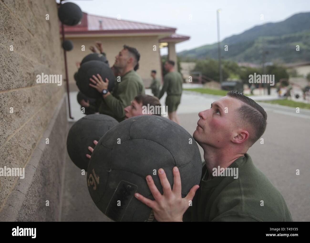 U.S. Marine Corps Sgt. Christopher Blackwood, radio operator with Marine Wing Communications Squadron 38, Marine Aircraft Control Group 38, 3rd Marine Aircraft Wing, conducts a wall ball exercise as a part of a physical fitness training session during Sergeants Course at the Staff Non-Commissioned Officer Academy, Marine Corps Base Camp Pendleton, California, March 11, 2019. The importance of physical fitness is one of the focal points of the Sergeants Course, however, the main emphasis is placed on leadership, war fighting tactics, administration and the communication skills necessary for a s Stock Photo