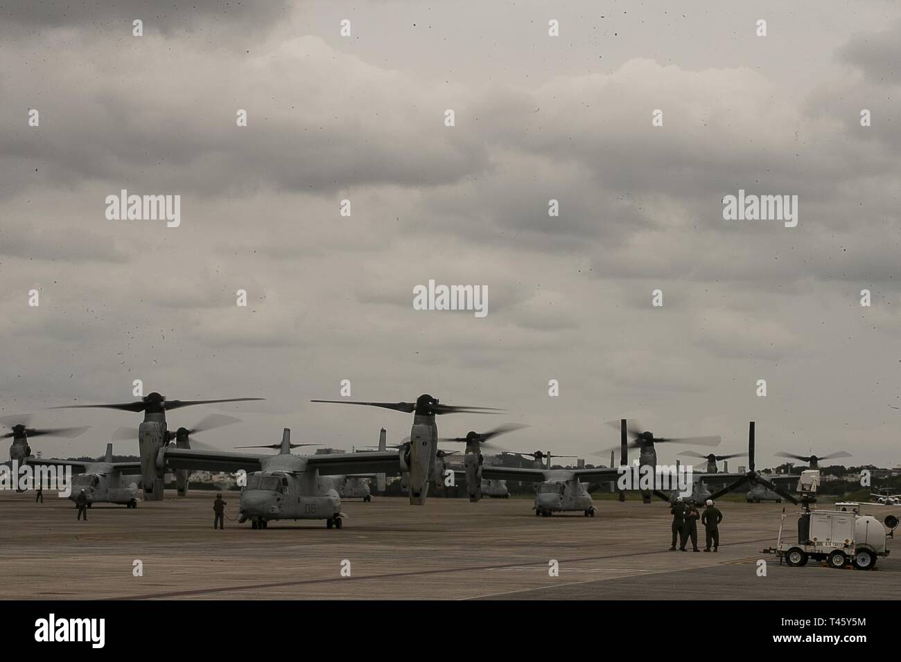 MV-22B Osprey tiltrotor aircraft belonging to Marine Medium Tiltrotor Squadron 262 (Reinforced) idle before flight atop the flight line at Marine Corps Air Station Futenma, Okinawa, Japan, March 11, 2019. VMM-262 (Rein.) is the Aviation Combat Element for the 31st Marine Expeditionary Unit. Marines with the 31st MEU are conducting simulated EABO in a series of dynamic training events to refine their ability to plan, rehearse and complete a variety of missions. During EABO, the 31st MEU partnered with the 3rd Marine Division, 3rd Marine Logistics Group and 1st Marine Aircraft Wing, and airmen w Stock Photo