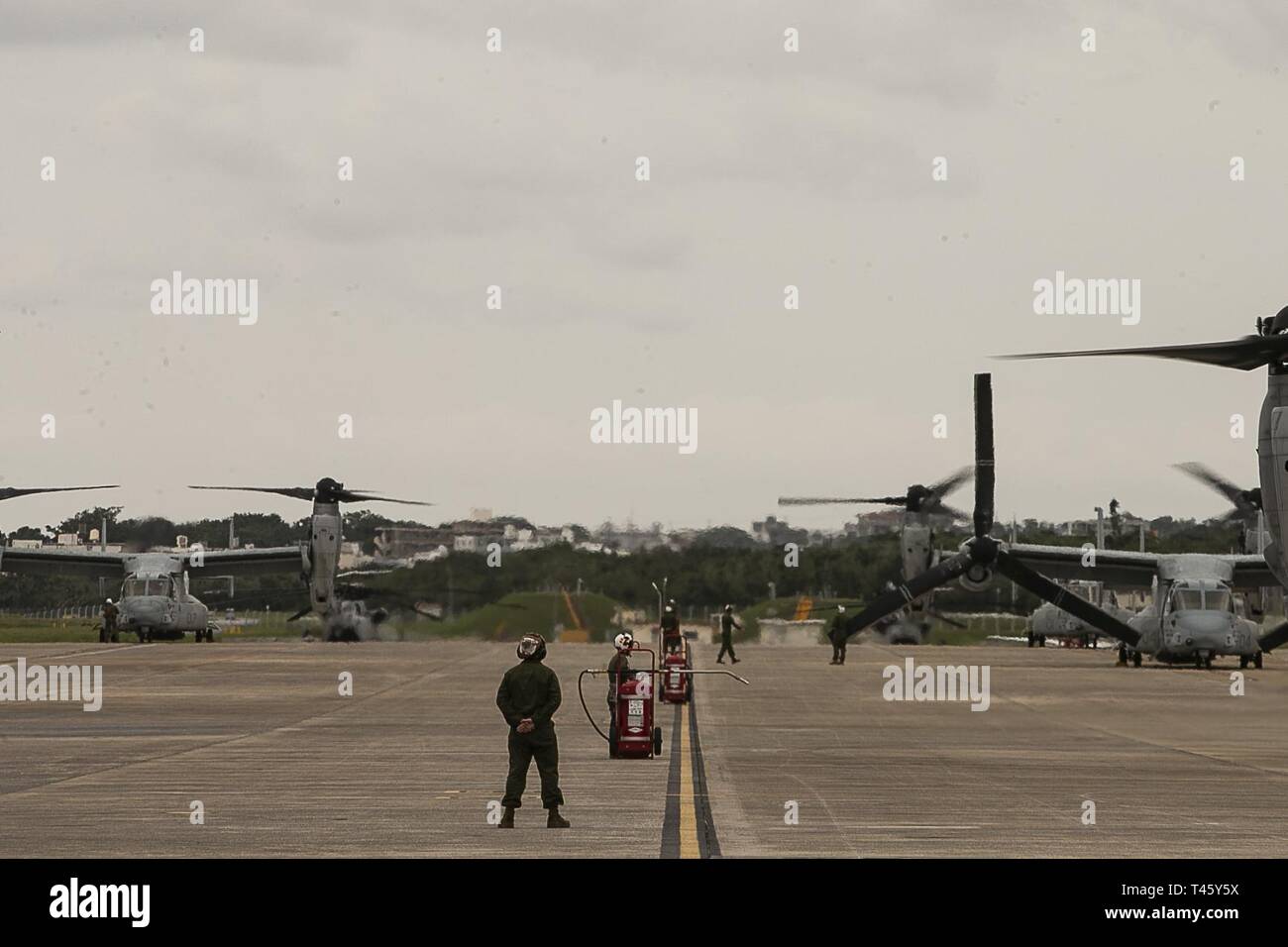 Marines with Marine Medium Tiltrotor Squadron 262 (Reinforced) watch pre-flight operations at Marine Corps Air Station Futenma, Okinawa, Japan, March 11, 2019. VMM-262 (Rein.) is the Aviation Combat Element for the 31st Marine Expeditionary Unit. Marines with the 31st MEU are conducting simulated EABO in a series of dynamic training events to refine their ability to plan, rehearse and complete a variety of missions. During EABO, the 31st MEU partnered with the 3rd Marine Division, 3rd Marine Logistics Group and 1st Marine Aircraft Wing, and airmen with the U.S. Air Force 353rd Special Operatio Stock Photo