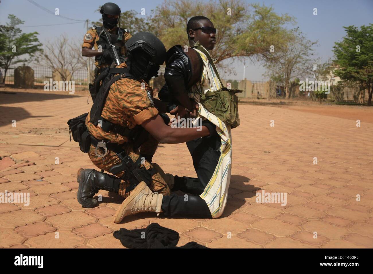 Burkina Faso Soldiers, assigned Special Program Embassy Augmentation Response (SPEAR) apprehend a terrorist actor during a simulated hostage situation in Ouagadougou, Burkina Faso on Feb. 27, 2019. The SPEAR soldiers demonstrated their abilities to Ambassador Andrew Young and multiple others. Stock Photo