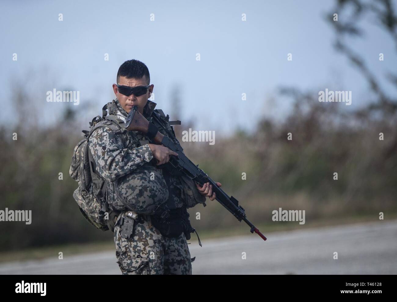 A Japan Self-Defense Force security force member establishes a perimeter on the flight line at Tinian, U.S. Commonwealth of the Northern Marianas Islands during Cope North Feb. 27, 2019. Cope North is an annual multilateral U.S. Pacific Air Forces-sponsored field training exercise focused on combat air forces large-force employment and mobility air forces humanitarian assistance and disaster relief training to enhance interoperability among U.S., Australian and Japanese forces. Stock Photo