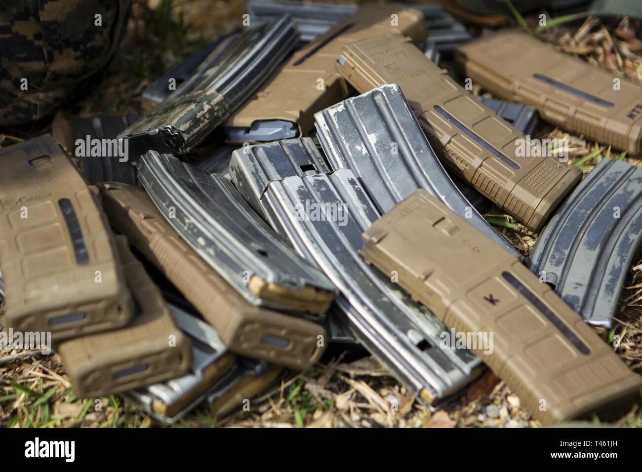 Magazines lay in a pile waiting for ammunition before platoon attack training at Camp Schwab, Okinawa, Japan, Feb. 28, 2019. During the training, Marines with Charlie Company, Battalion Landing Team, 1st Battalion, 4th Marines refined their ability “To locate, close with and destroy the enemy by fire and maneuver, or repel the enemy’s assault by fire and close combat,” the mission of the Marine Corps rifle squad. Charlie Company Marines are the airborne raid specialists with BLT 1/4, the Ground Combat Element for the 31st Marine Expeditionary Unit. The 31st MEU, the Marine Corps’ only continuo Stock Photo