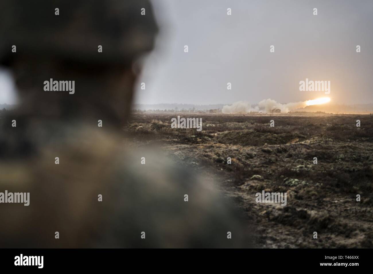 U.S. Marine Corps Sgt. Andy O. Martinez, a mass communicator with Marine Forces Reserve’s Communication Strategy and Operations section, watches a High Mobility Artillery Rocket System fire a rocket during live-fire range at Adazi Training Area, Latvia, March 4, 2019, during exercise Dynamic Front 19. Two HIMARS from Fox Battery, 2nd Battalion, 14th Marine Regiment, 4th Marine Division, coordinated fires with army units in Germany. Approximately 3,200 participants from 27 nations will take part in the live-fire portion of exercise Dynamic Front 19, March 2-9, 2019, at the U.S. Army's Grafenwoe Stock Photo