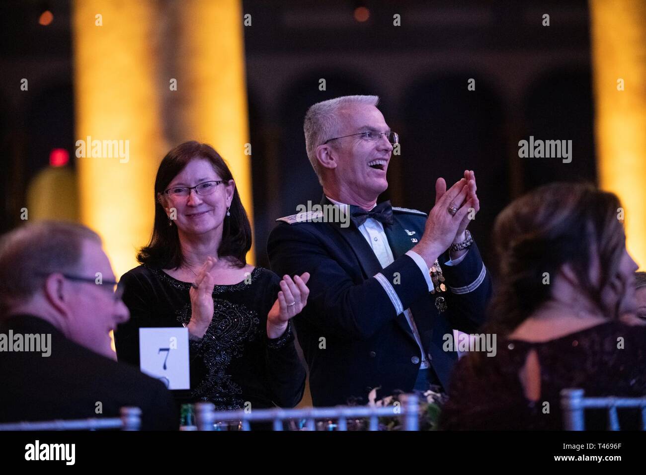 Air Force Gen. Paul J. Selva, vice chairman of the Joint Chiefs of Staff, right; and his wife, Mrs. Ricki Selva, left; react to the masters of ceremony, ABC News Investigative Correspondent Kyra Phillips and Chief White House Correspondent for FOX News Channel John Roberts, during the 2019 Tragedy Assistance Program for Survivors (TAPS) Honor Guard Gala at the National Building Museum in Washington D.C., March 6, 2019. TAPS is a not-for-profit organization that has assisted over 70,000 surviving family members grieving the loss of an armed forces service-member. Stock Photo