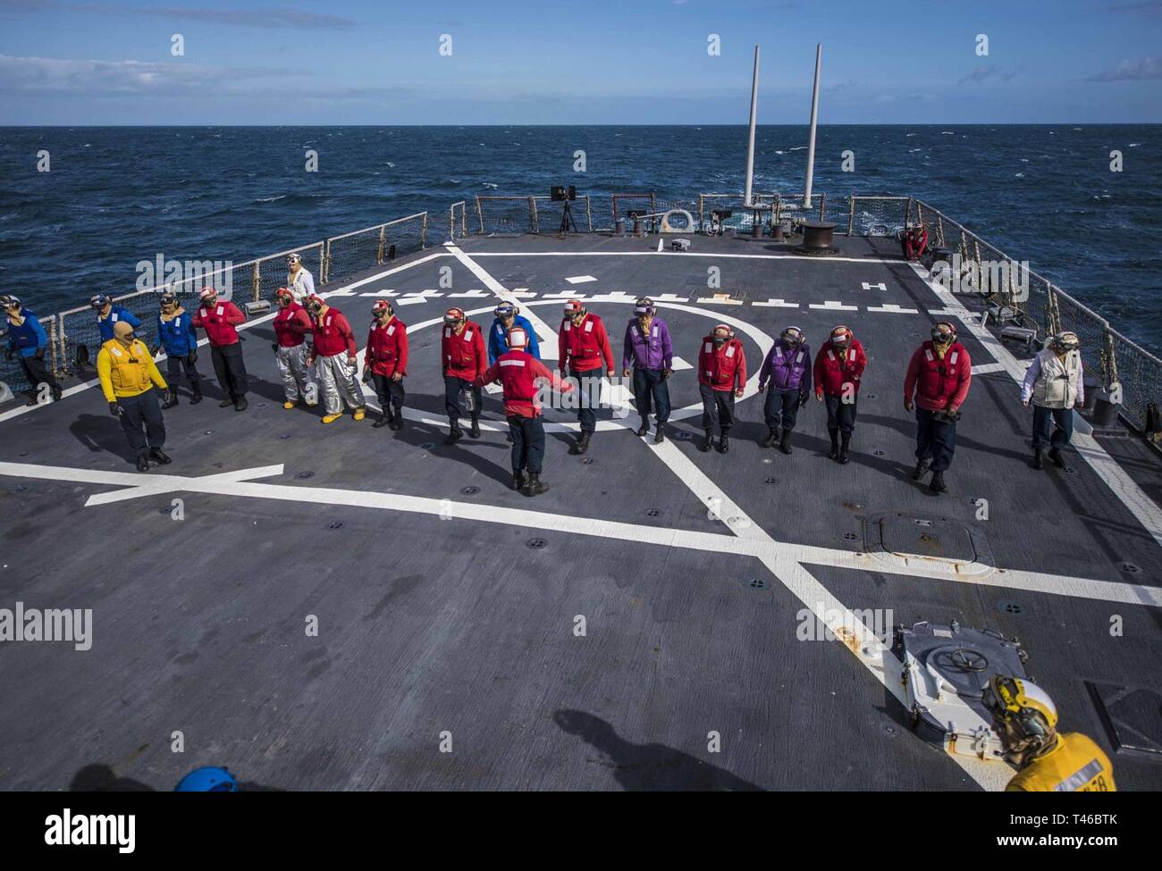 OCEAN (March 11, 2019) – Sailors aboard the Arleigh Burke-class guided-missile destroyer USS Porter (DDG 78) search for foreign object debris before flight quarters in the Atlantic Ocean, March 11, 2019. Porter, forward-deployed to Rota, Spain, is on its sixth patrol in the U.S. 6th Fleet area of operations in support of U.S national security interests in Europe and Africa. Stock Photo