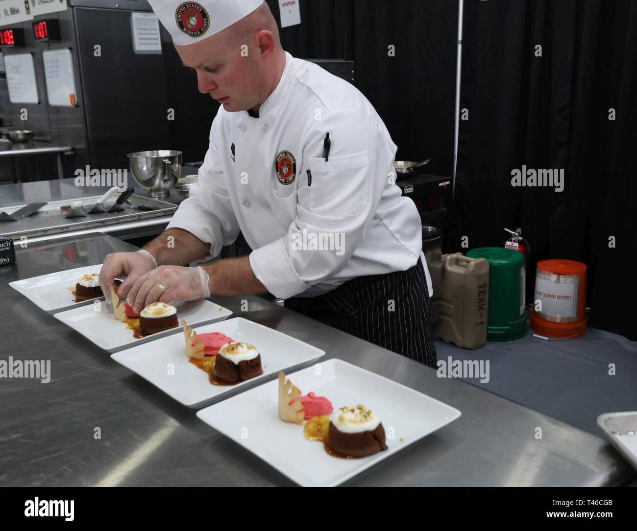 Gunnery Sgt. Michael Watts, food service specialist, U.S. Marines, place a  cookie on his plated dessert as part of the pastry chef of the year event  March 11 as part of the, image size:1300x1083