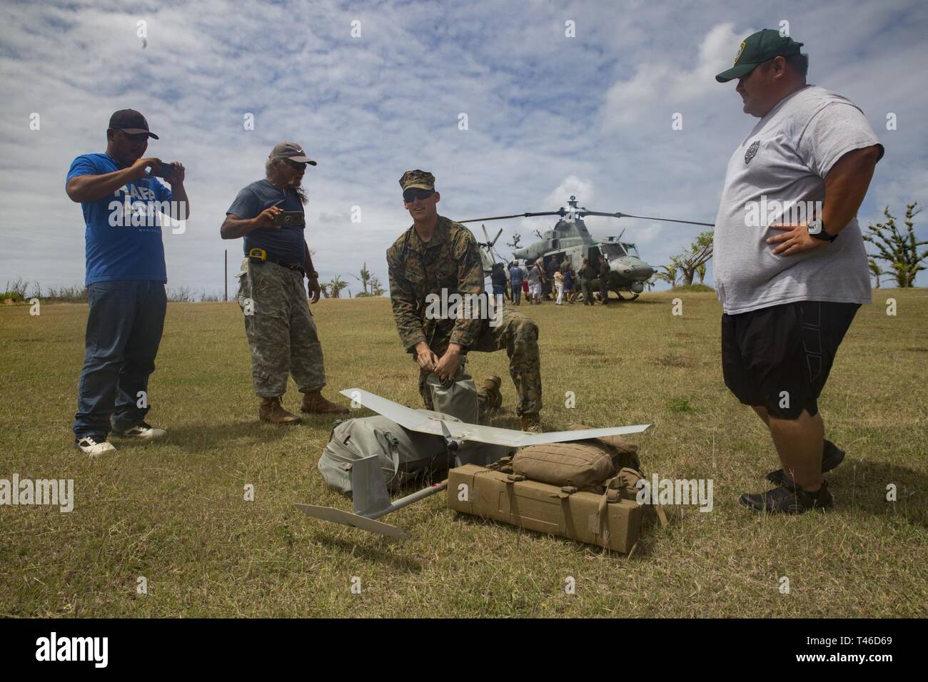 Sgt. Connor Ogara, an intelligence specialist with Alpha Company, Battalion Landing Team, 1st Battalion, 4th Marines, showcases an unmanned aerial system for residents of Tinian, Commonwealth of the Northern Mariana Islands, March 11, 2019. Marines and Sailors with Combat Logistics Battalion 31 led a multi-service task force, partnering with the Federal Emergency Management Agency, to help the U.S. citizens of Tinian begin recovery efforts in the wake of Super Typhoon Yutu last year. The Marines and Sailors, currently participating in two weeks of unit-level training on nearby Guam, visited Ti Stock Photo