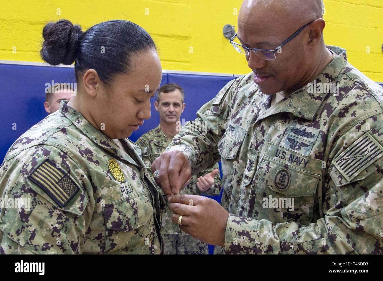NAVAL SUPPORT ACTIVITY SOUDA BAY, Greece (March 11, 2019) U.S. Naval Forces Europe-Africa Fleet Master Chief Raymond D. Kemp promotes Master-at-Arms 3rd Class Angelina Pulu to Petty Officer 2nd Class during an awards ceremony onboard Naval Support Activity (NSA) Souda Bay, March 11, 2019. NSA Souda Bay is an operational ashore base that enables U.S., allied, and partner nation forces to be where they are needed and when they are needed to ensure security and stability in Europe, Africa, and Southwest Asia. Stock Photo