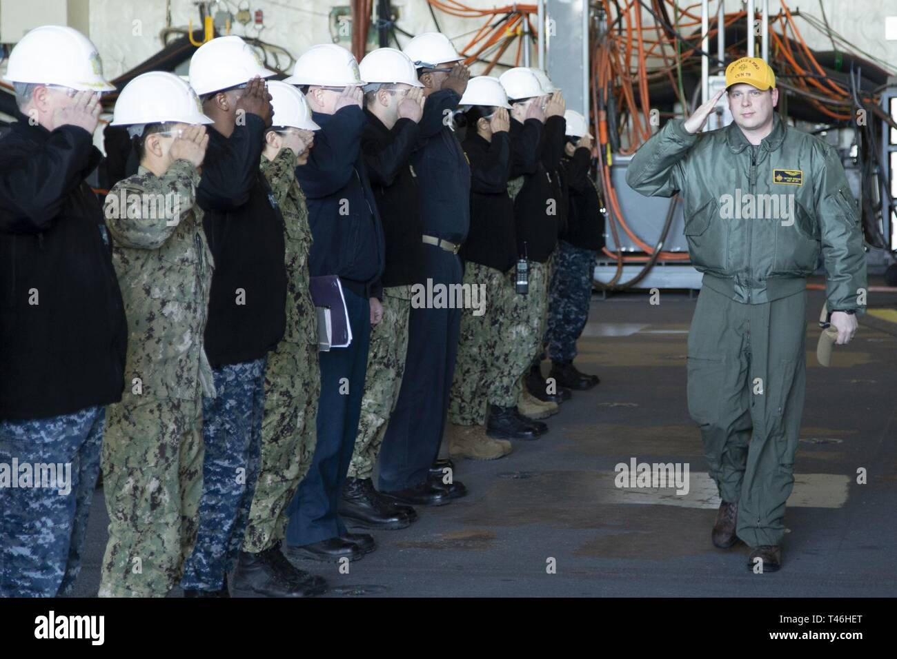 NEWPORT NEWS, Va. (March 12, 2019) Lt. Matthew Herbaugh, from Aynor, South Carolina, USS Gerald R. Ford's (CVN 78) assistant air operations officer, returns the salutes of officers as he is piped ashore. Ford is currently undergoing its post-shakedown availability at Huntington Ingalls Industries-Newport News Shipbuilding. Stock Photo