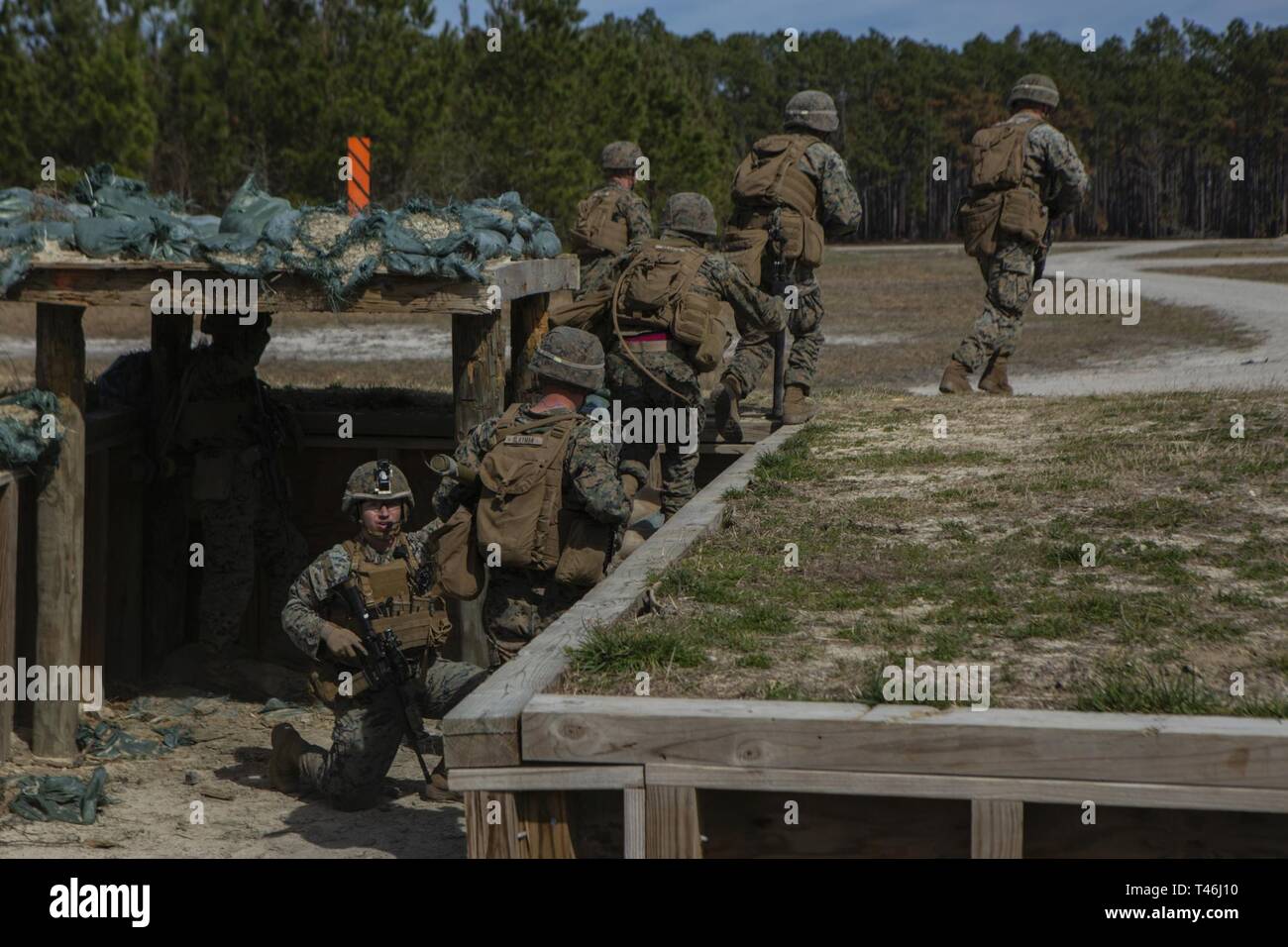 U.S. Marines with 2nd Combat Engineer Battalion, 2nd Marine Division, sprint out of a trench while conducting breaching operations during the annual SAPPER Squad Competition on Camp Lejeune, North Carolina, March 12, 2019. Marines from four squads compete against each other for a week to test their strengths within the occupational field and build camaraderie while maintaining mission readiness. Stock Photo