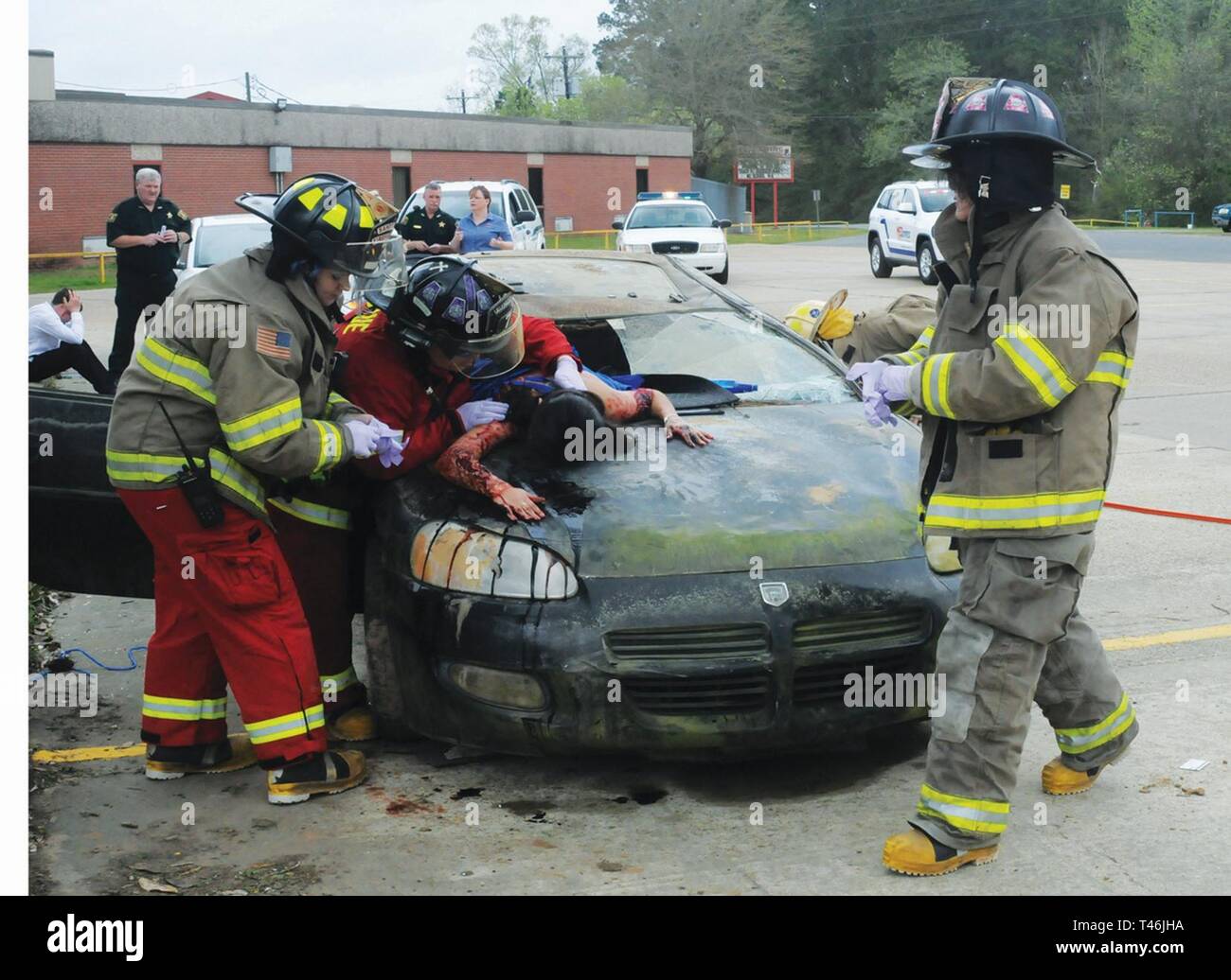 Sandy Hill Fire and Rescue arrives at the scene and begins to assess simulated injuries. They are checking on the victim that flew through the car windshield, played by Pickering High School student Jaquelin Lopez, 16. The demonstration about what can happen when drinking and driving mix took place at Pickering High School March 13. Stock Photo