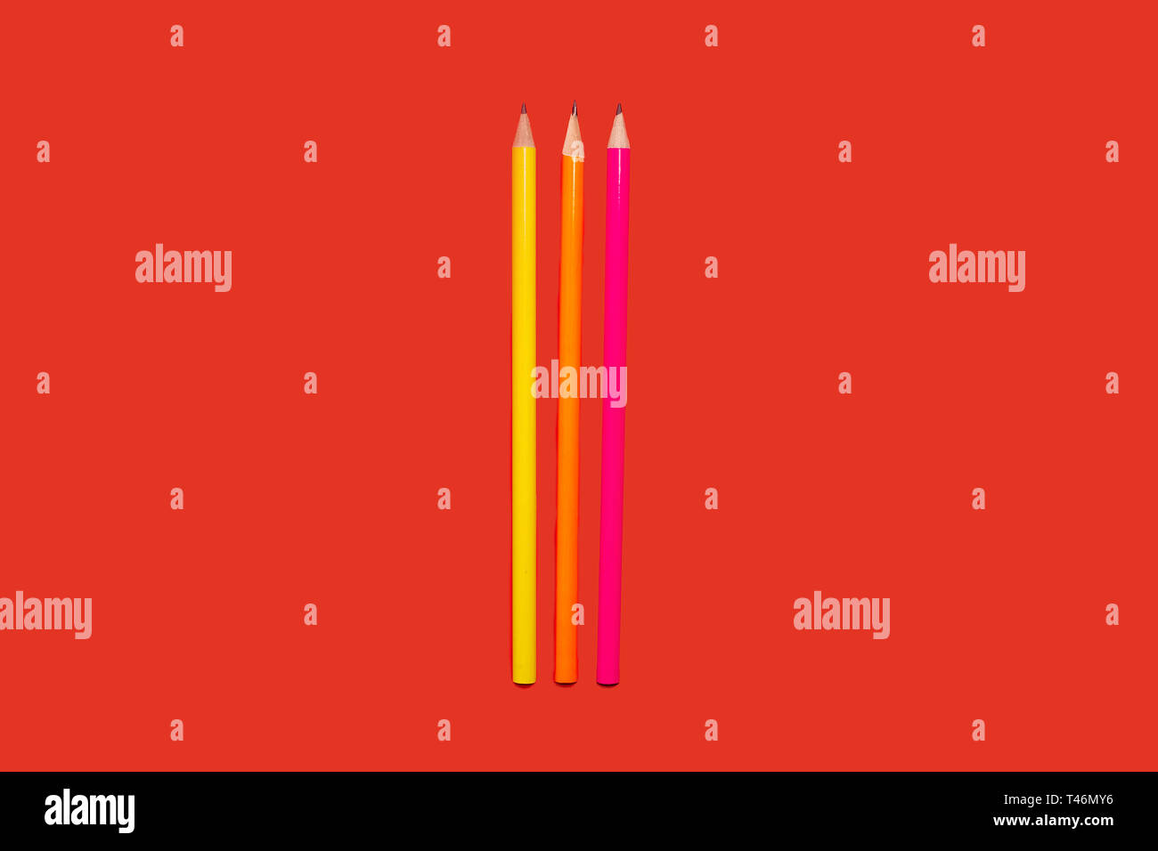 colored pencils lying on a red background Stock Photo