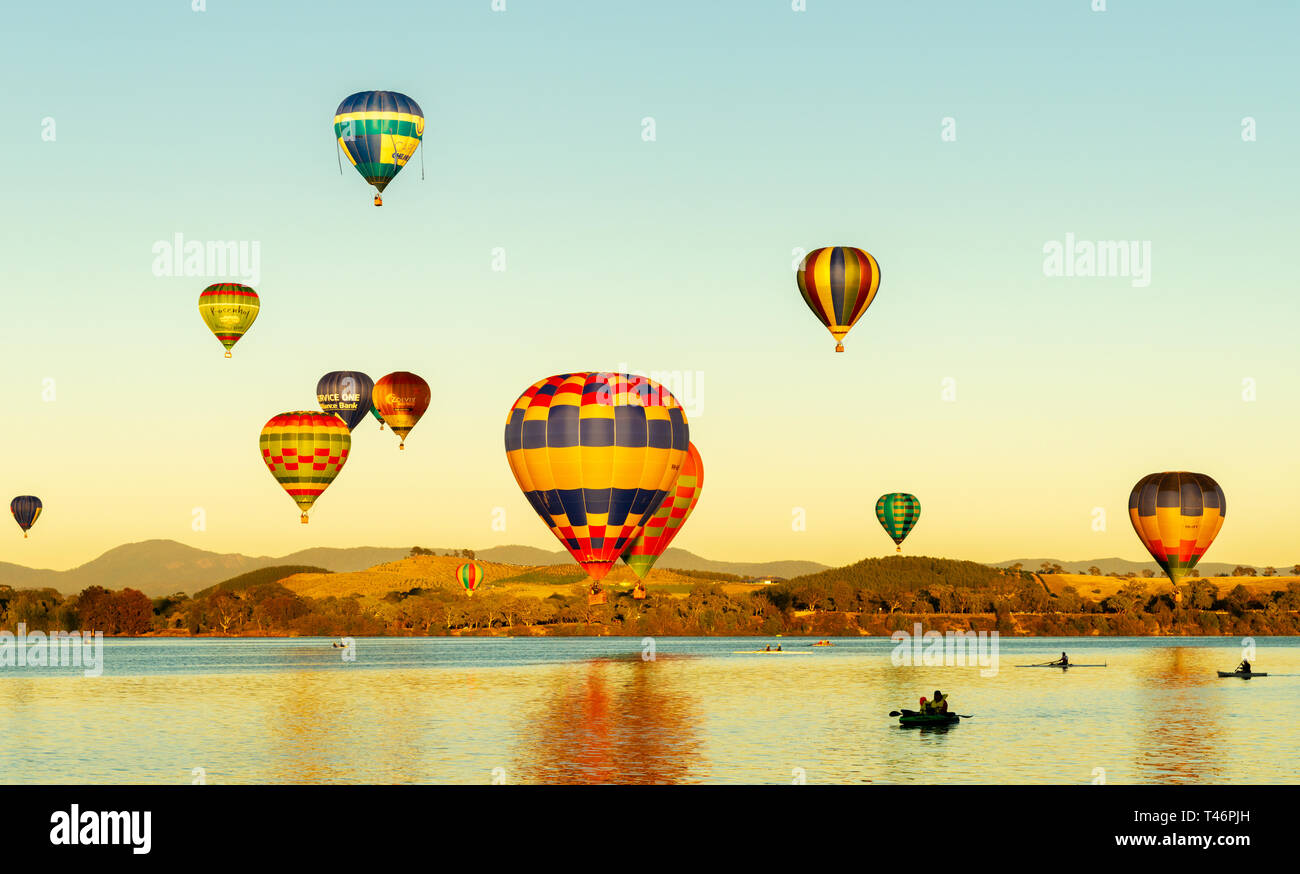Canberra, Australia, March 11th, 2019, Hot air balloons flying across water during the annual festival. Stock Photo