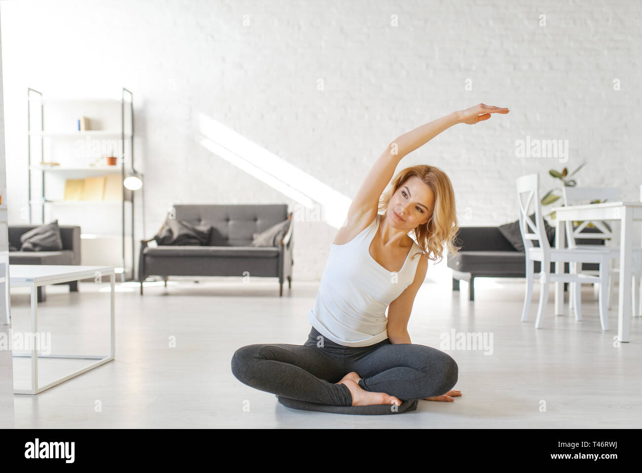Yuong woman sitting on the floor in yoga pose Stock Photo - Alamy