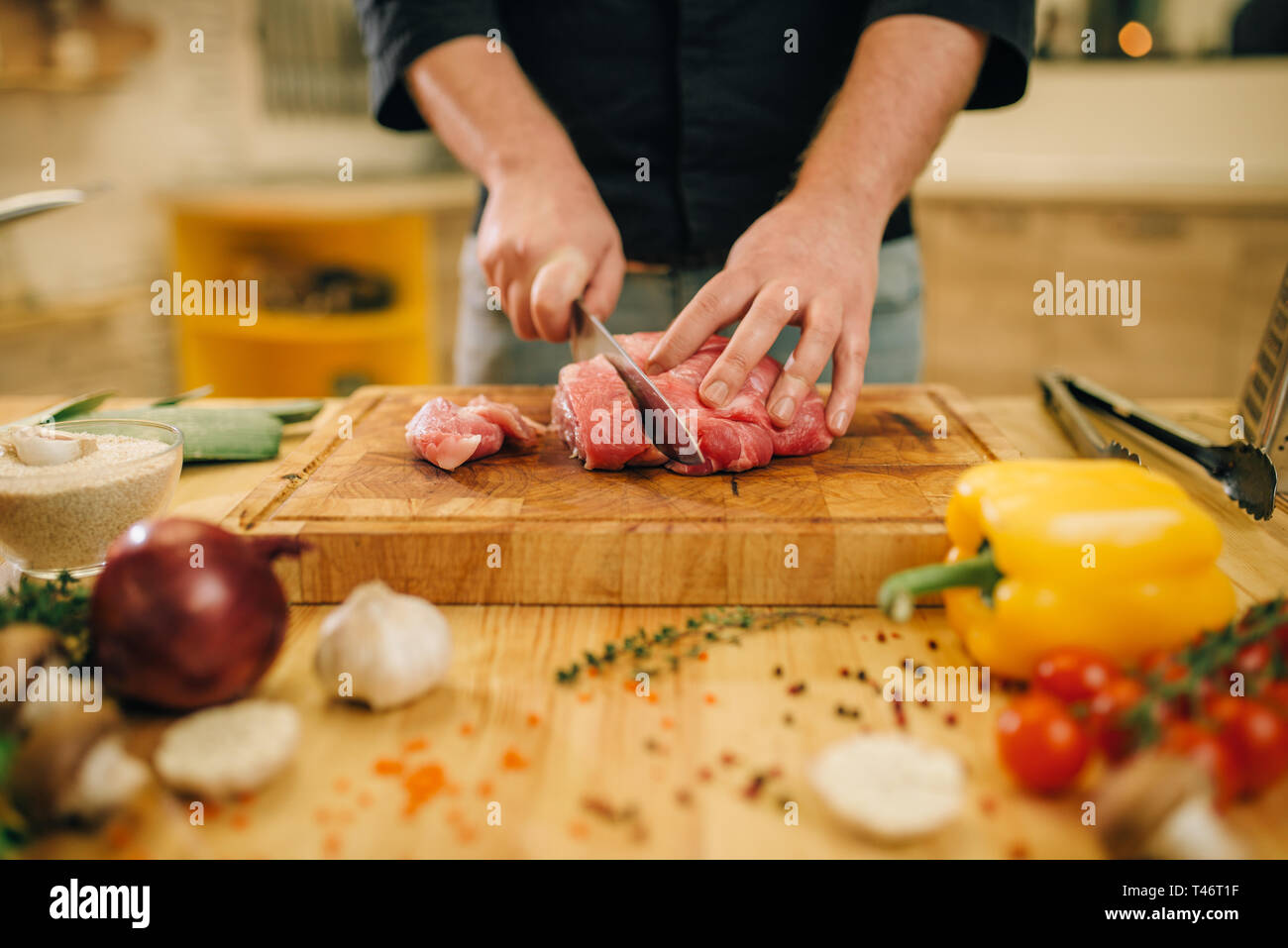 Male person with knife cuts raw meat into slices Stock Photo - Alamy