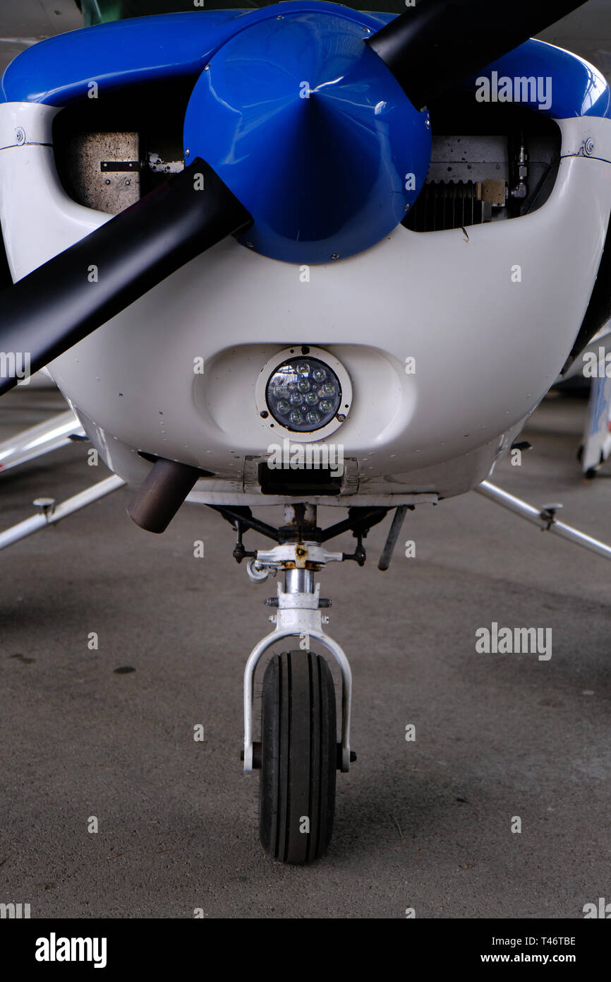 Small sport aircraft in hangar, front view of engine, propeller and nose wheel, aviation and adventure concept Stock Photo