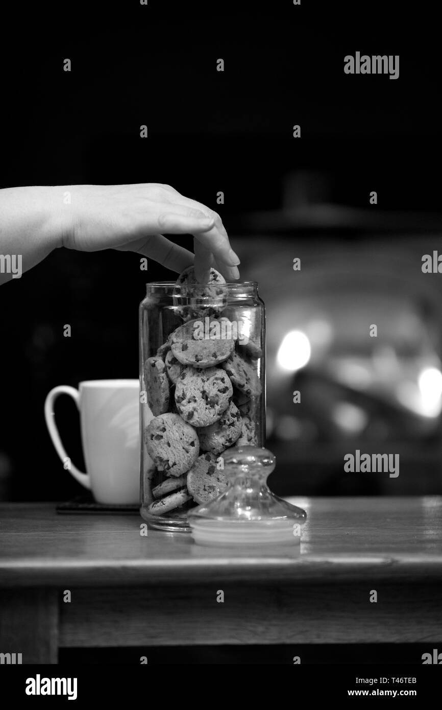 A hand in the cookie jar whilst having an evening by the fire. Stock Photo