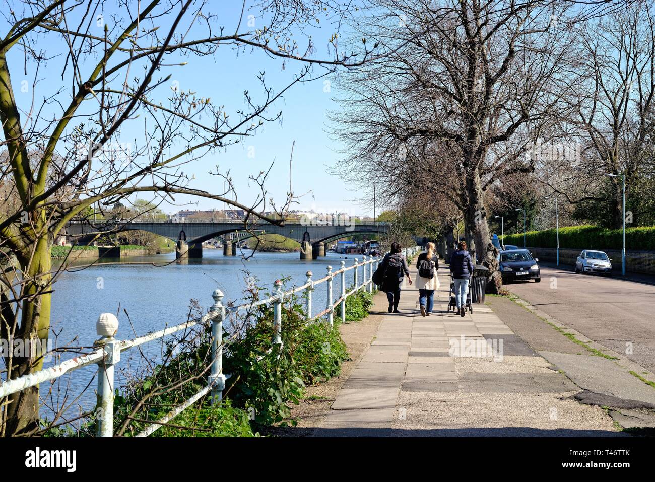 Rear view of three young mothers with pushchair walking by the River Thames on Ranelagh Drive St Magarets Twickenham Surrey England UK Stock Photo