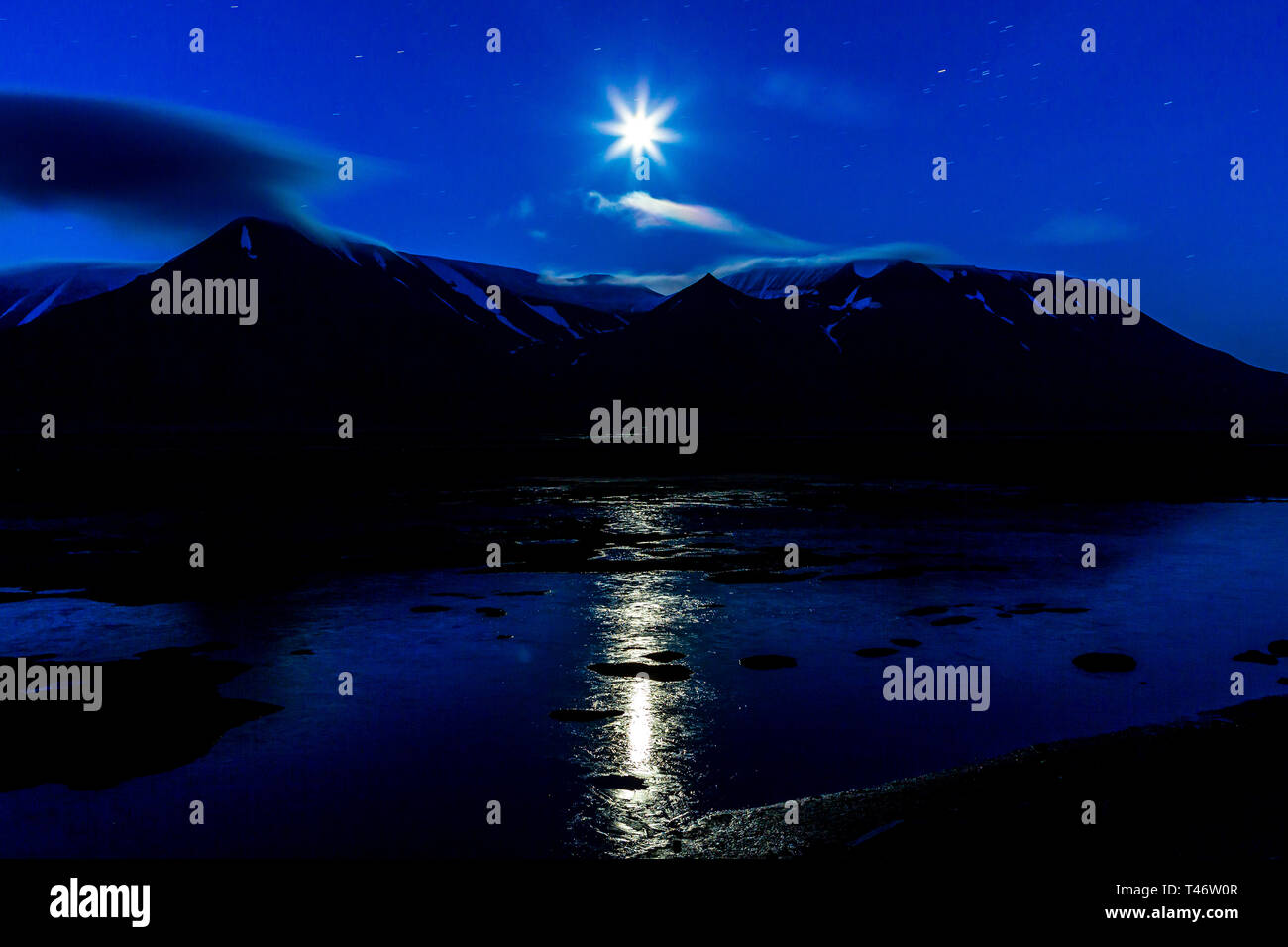 norway landscape moon reflection in the water adventdalen Spitsbergen Longyearbyen Mountain Svalbard arctic ocean Stock Photo