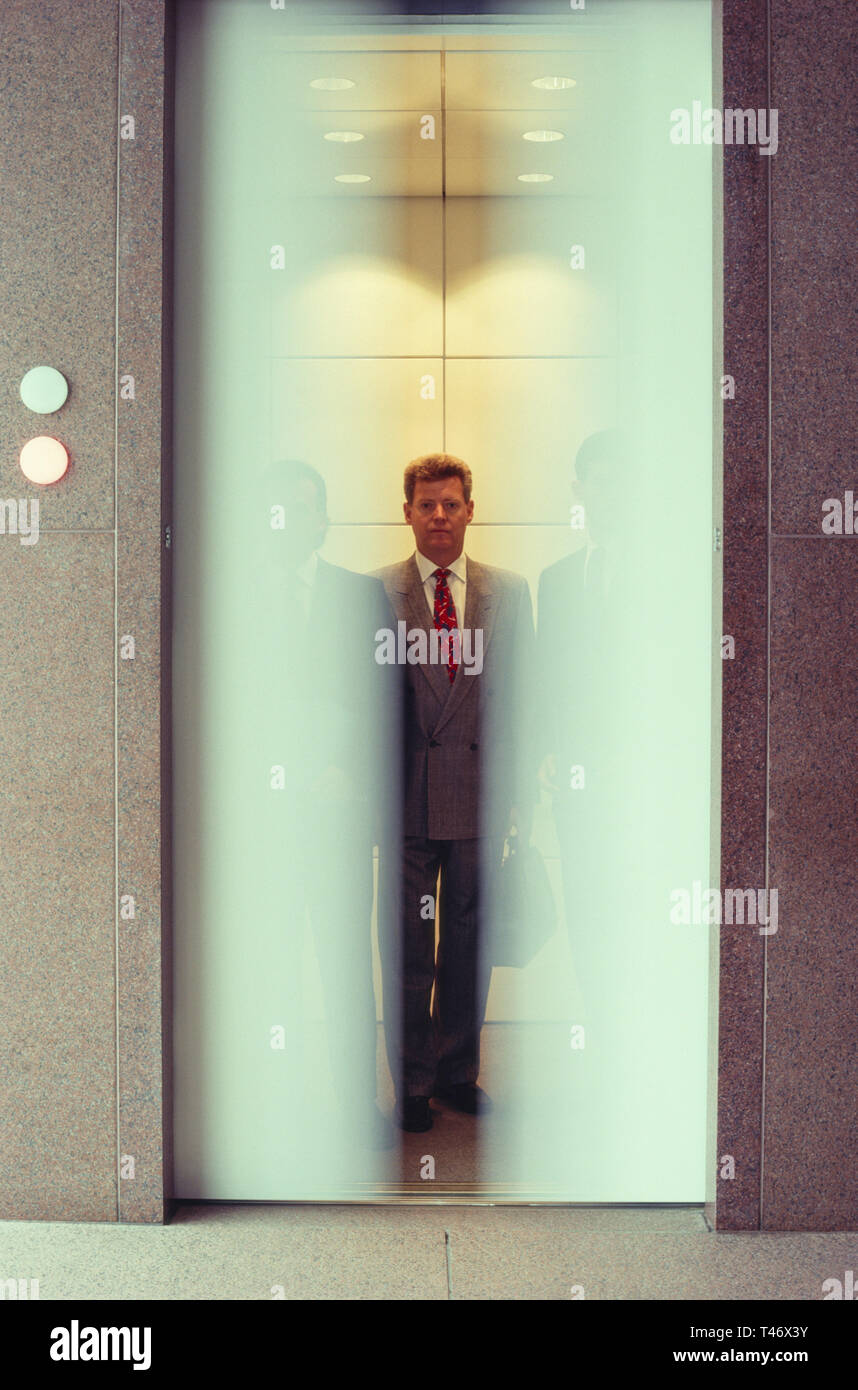 Businessmen in elevator with door movement, USA  1991 Stock Photo
